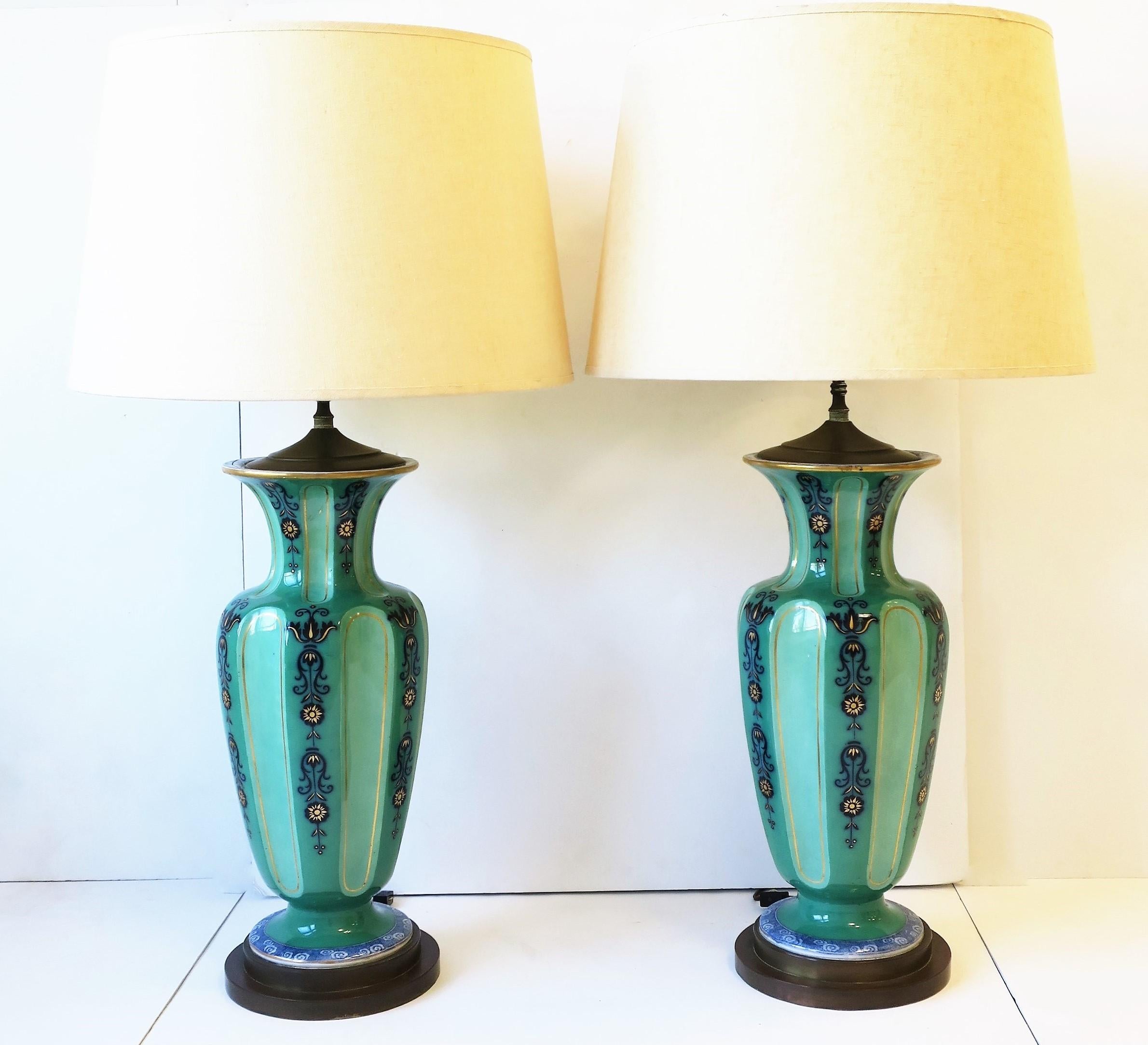 Una bellissima coppia di grandi e alte lampade da tavolo olandesi in porcellana con finiture in ottone, circa inizio XX secolo, anni '30, Olanda. I colori includono verde smeraldo, verde chiaro, blu zaffiro, azzurro, bianco e tocchi d'oro.