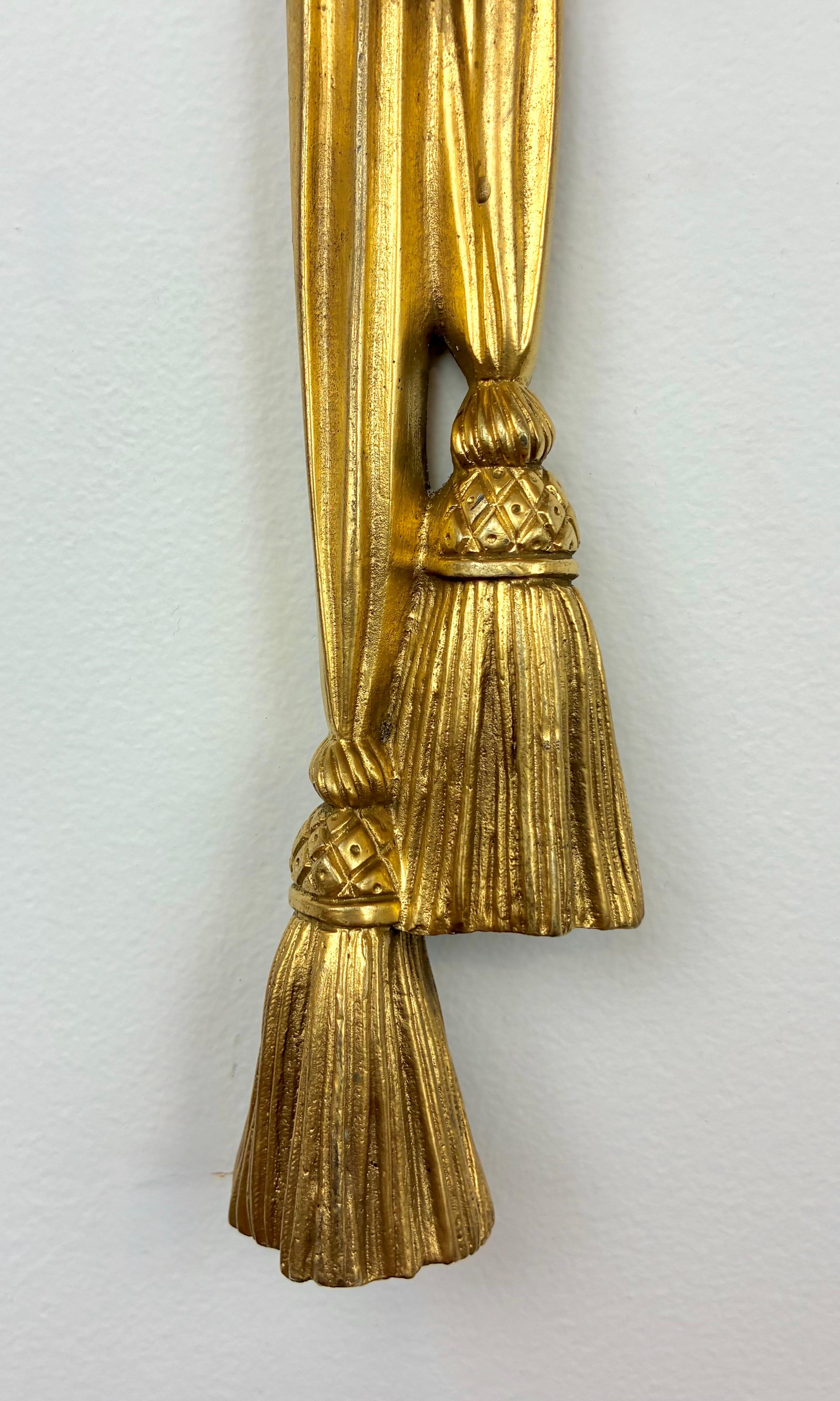 Este impresionante par de apliques de gran tamaño son obra de la renombrada firma Edward F. Caldwell.
Conservan su pátina dorada original y presentan motivos clásicos, como hojas de acanto, rosetas y borlas. Están recién reelaborados y listos para