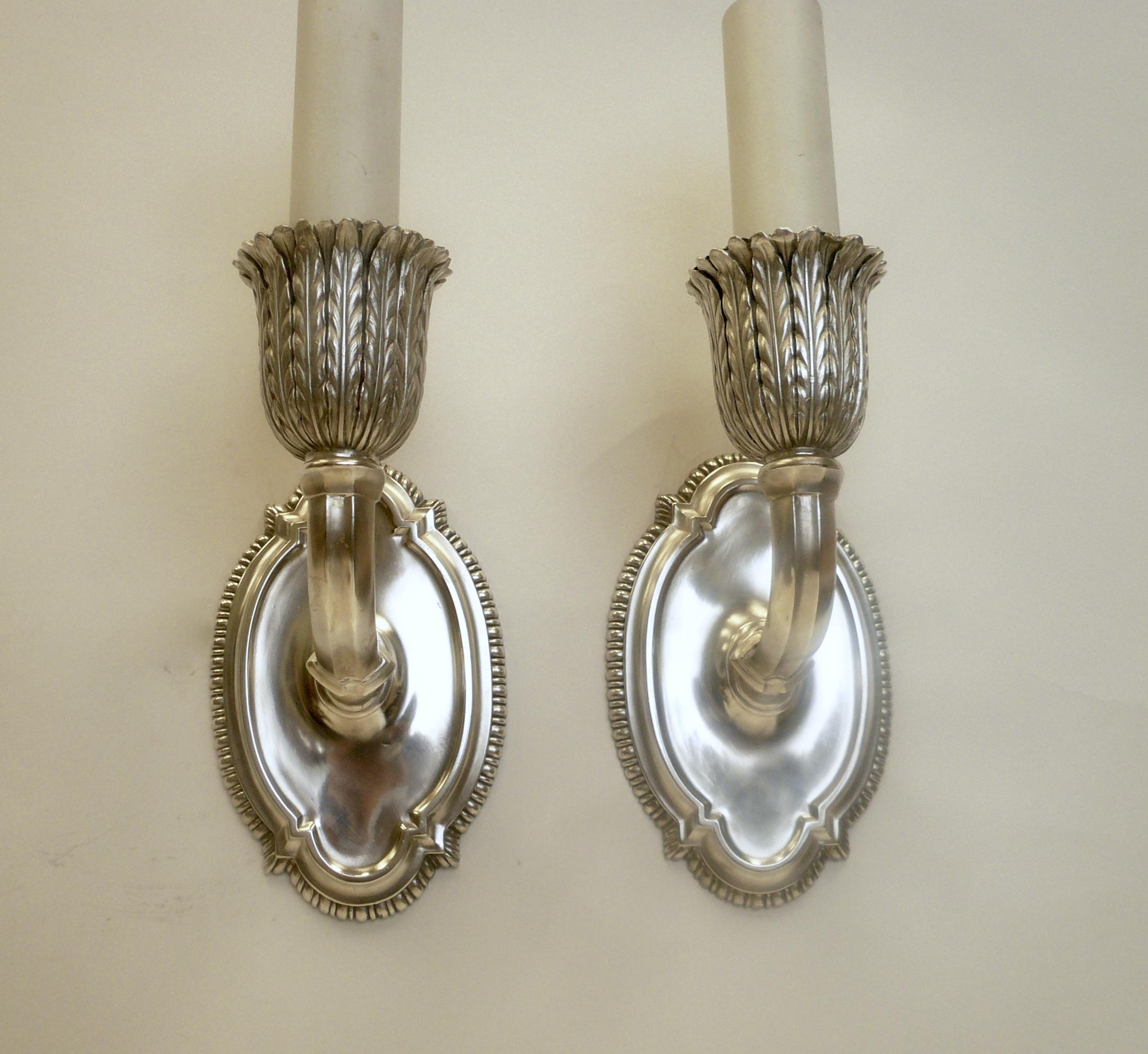 This handsome pair of Caldwell sconces feature beaded border back plated, and acanthus leaf form candle cups. They are newly rewired and ready for use.