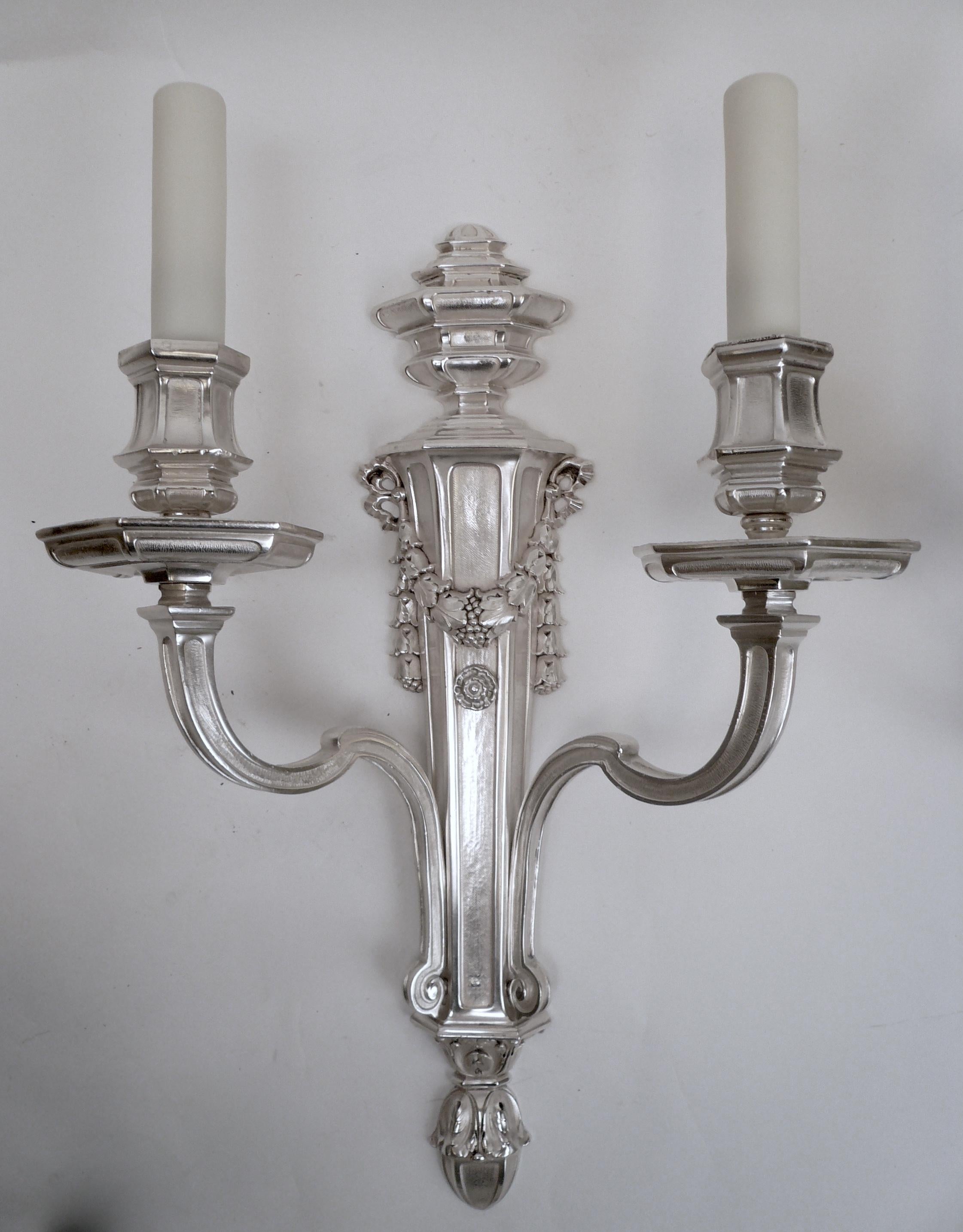 This handsome pair of signed Caldwell sconces feature Classical motifs including foliate swags, and acanthus leaves.