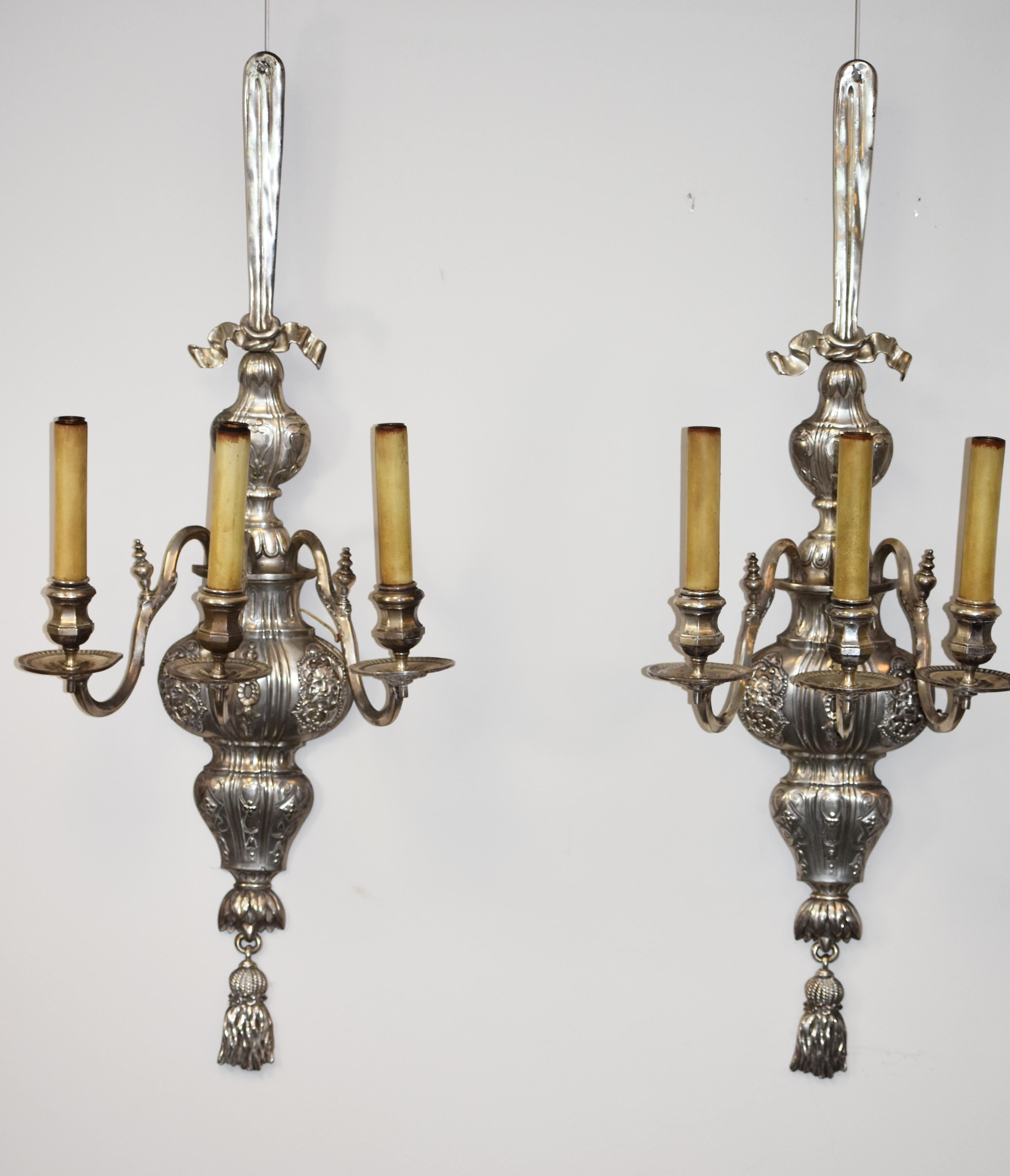 Large pair of silvered three arm sconces by E. F. Caldwell. The sconces retain their original finish.   They have been recently completely rewired.
Due to their size this pair of sconces make quite a visual impact.
The firm was one of the premier