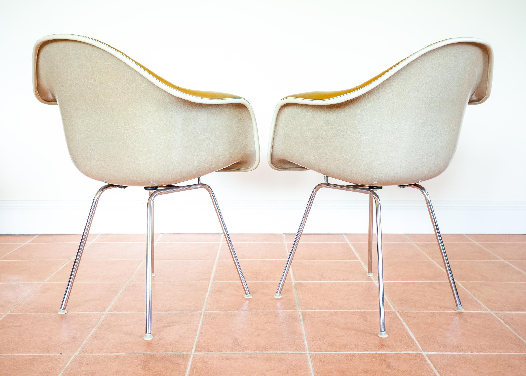 A gorgeous and extremely rare pair of early 1960s caramel leather Eames DAX armchairs. A very special collaborative pair between Herman Miller and Vitra, these stunning armchairs work as lounge chairs, occasional chairs or dining chairs and will add