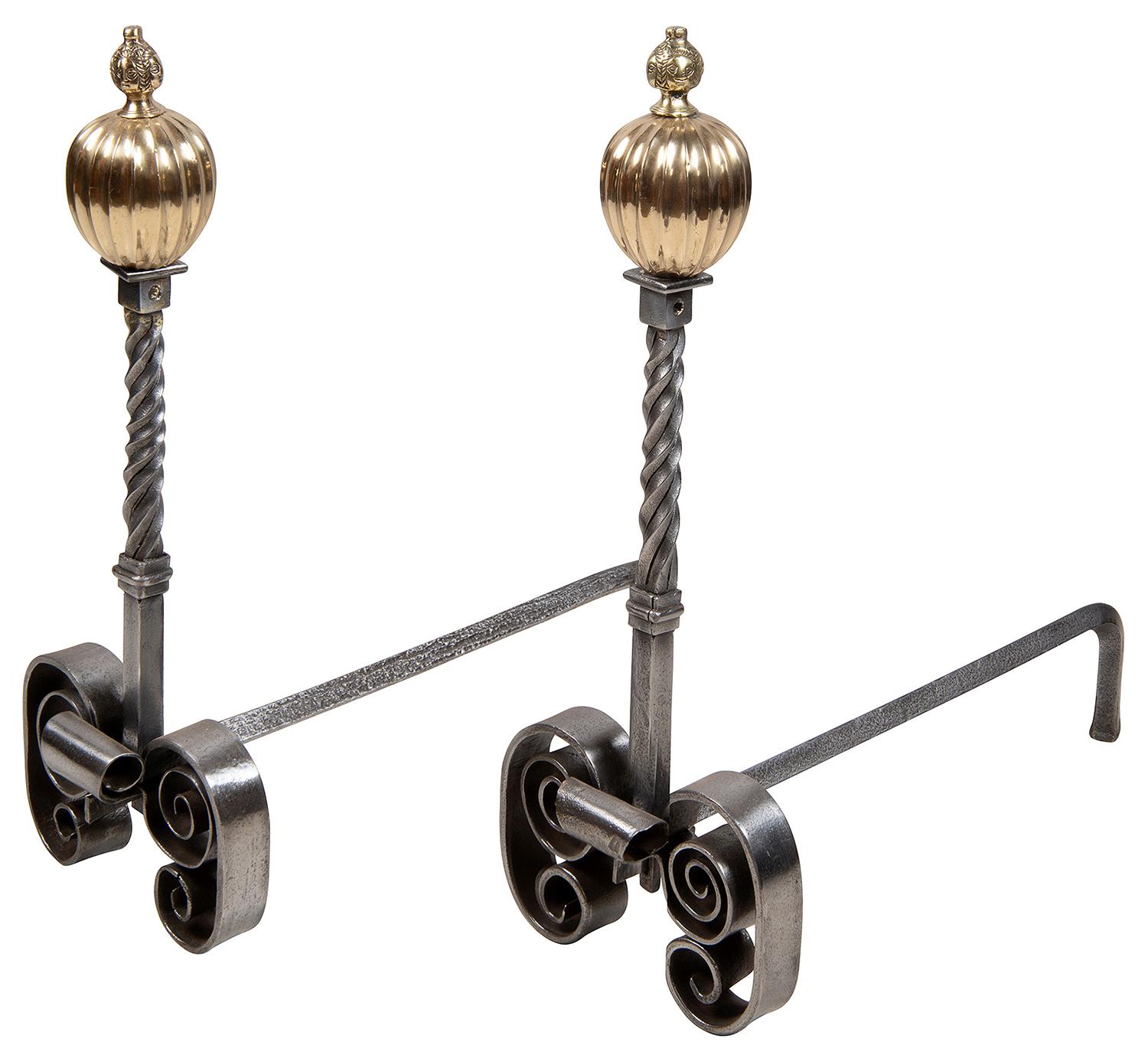 A good quality pair of early 19th century iron and brass andirons / fire dogs, each having reeded brass finials above twisted iron up rights and scrolling feet.