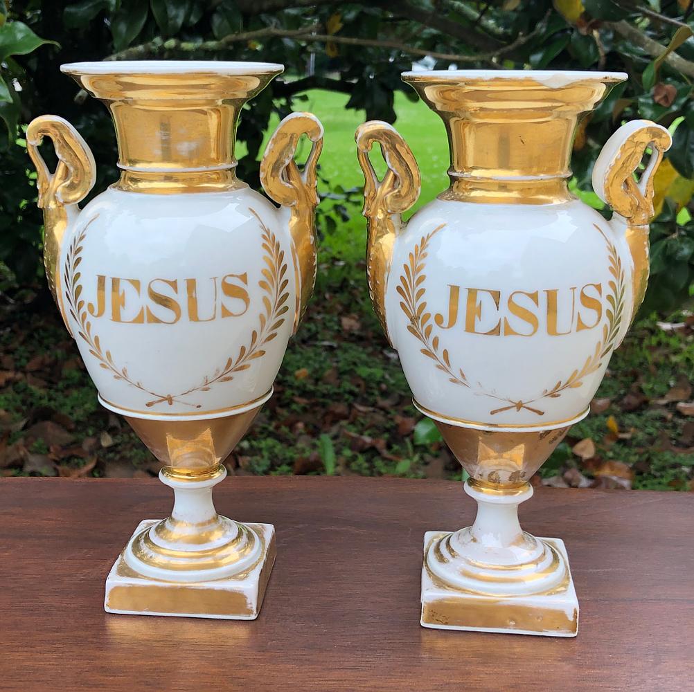 Pair early 19th century French Vieux Parishand-painted porcelain vases feature a religious theme, painted on one side with the name of Jesus, and on the other Marie, the French spelling for the Madonna. Classical Greco-Roman architecture is enhanced