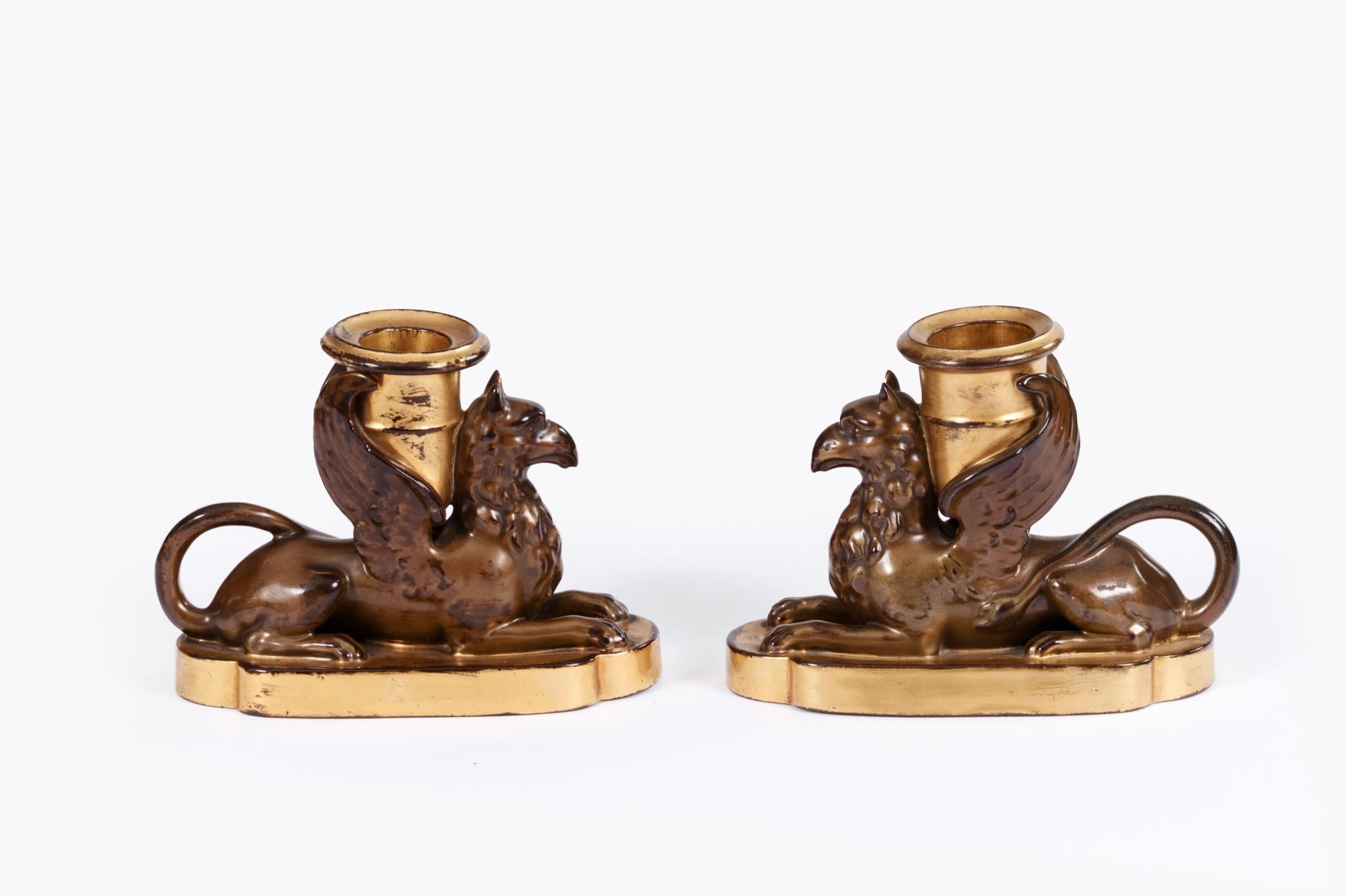 Paire de griffons en porcelaine anglaise Worcester du début du 19e siècle, décorés d'un effet de bronze simulé, sur une base plate en forme décorée de dorures, une applique à bougie et dorée sur le dos, entre les ailes. Les griffons symbolisent le