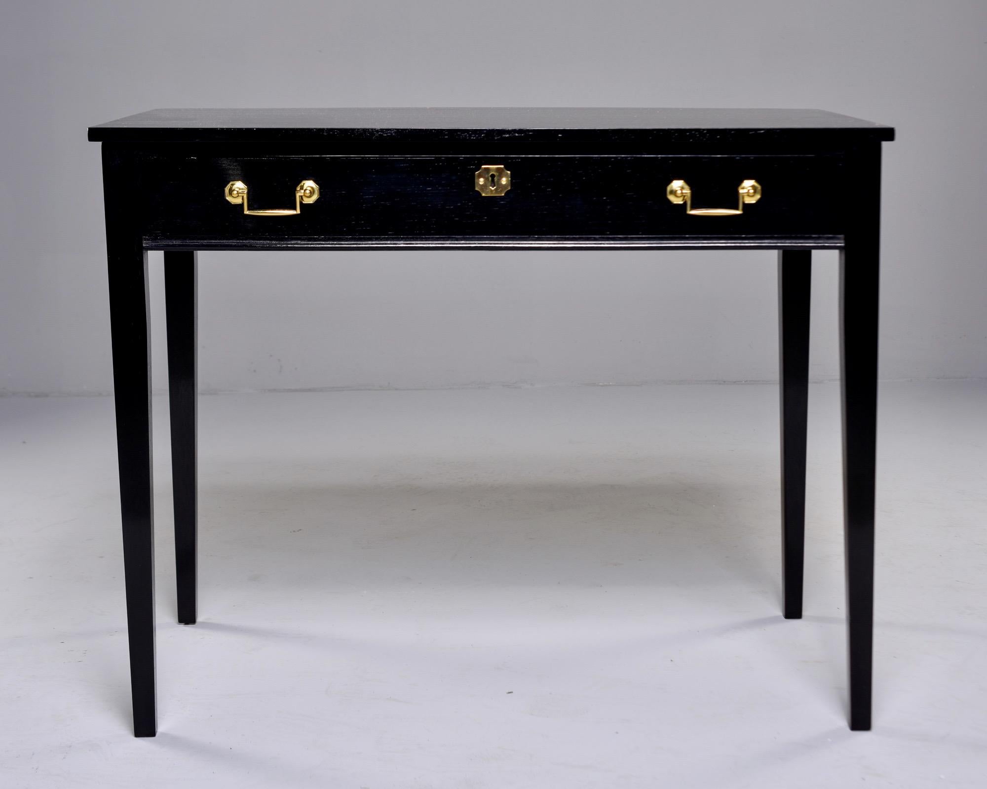 Circa 1900s pair of English writing desks with single locking center drawer and newly ebonised finish. Can be used as consoles or side tables. Sold and priced as a pair.