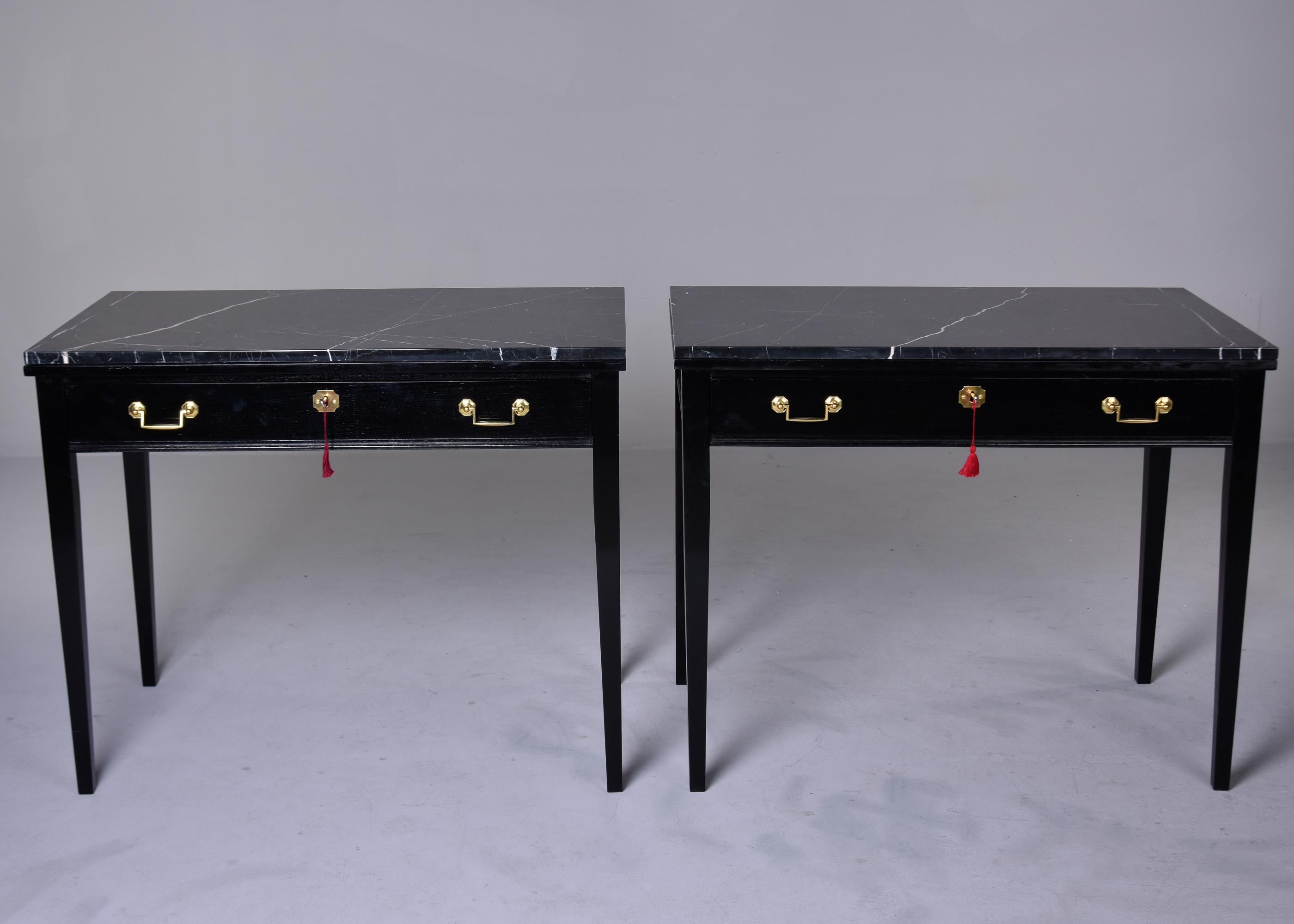 Circa 1900 pair of English writing desks with single locking center drawer and newly ebonised finish. Dovetail construction. Each desk has a new black marble top with white streaks. These pieces can also work as consoles or side tables. Unknown