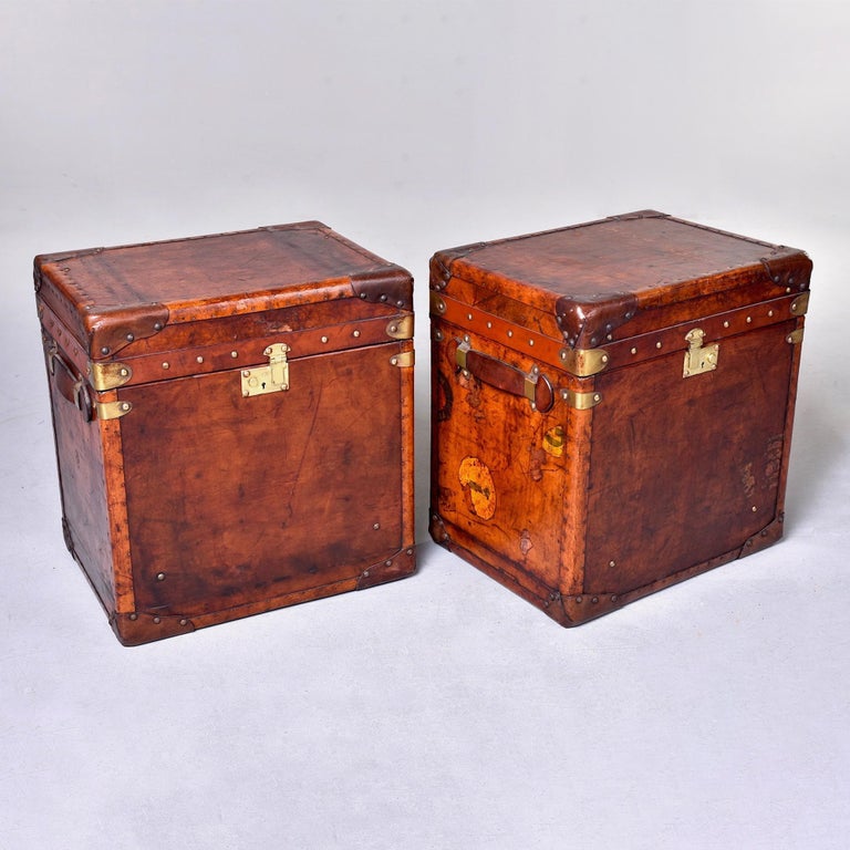 Found in England, this pair of circa 1900s pair of leather and brass trunks have been professionally restored. Leather has been reconditioned and the color has been deepened/toned Interiors have been recovered in a royal blue velour and the brass