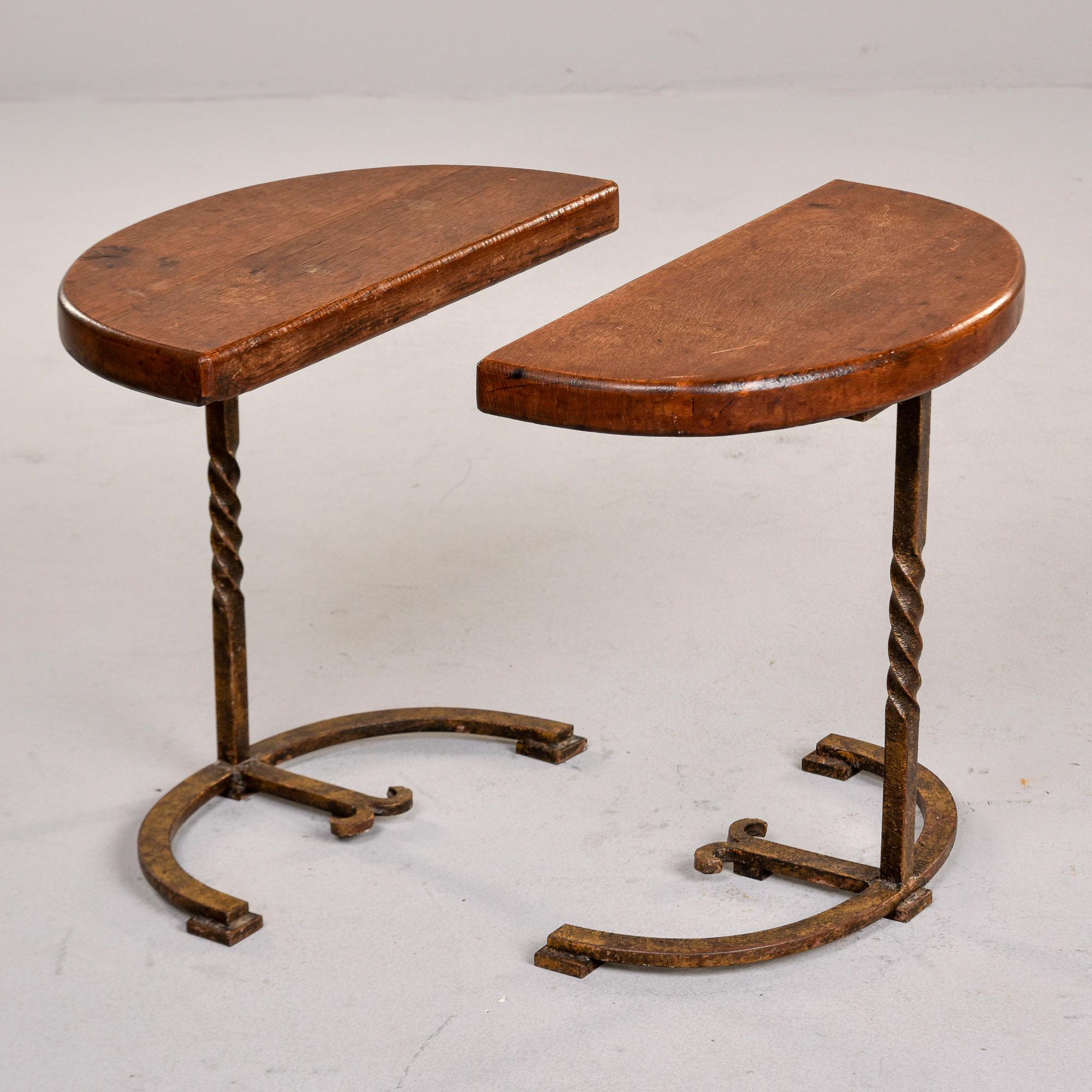 We found these tables in France but believe they are of Spanish origin and date from the 1930s. This pair of small demilune tables tops show honest wear - see detail photos -  and feature twisted iron legs with decorative ironwork on the base and