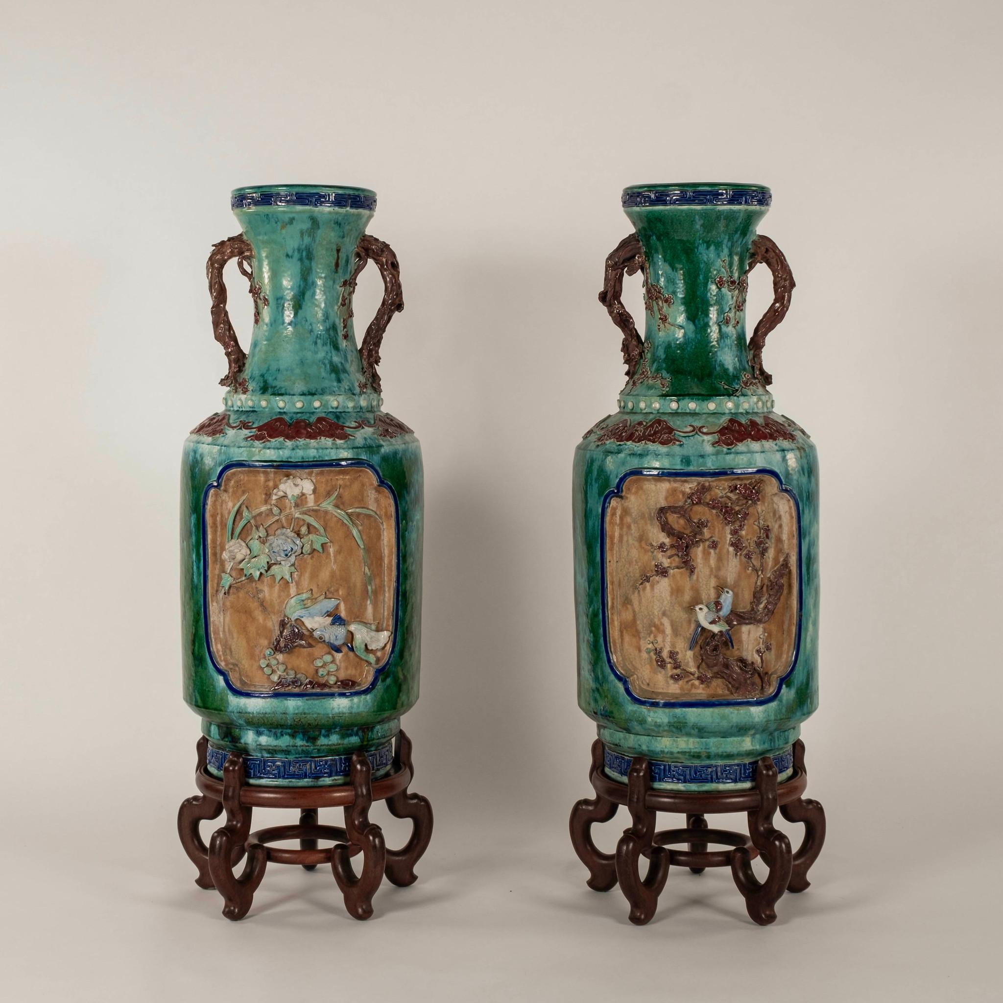 Une grande paire de vases en poterie de style Ming présentant une glaçure turquoise épaisse et fluide avec des oiseaux, des fleurs, des feuillages et des poissons. Pieds en bois inclus.

