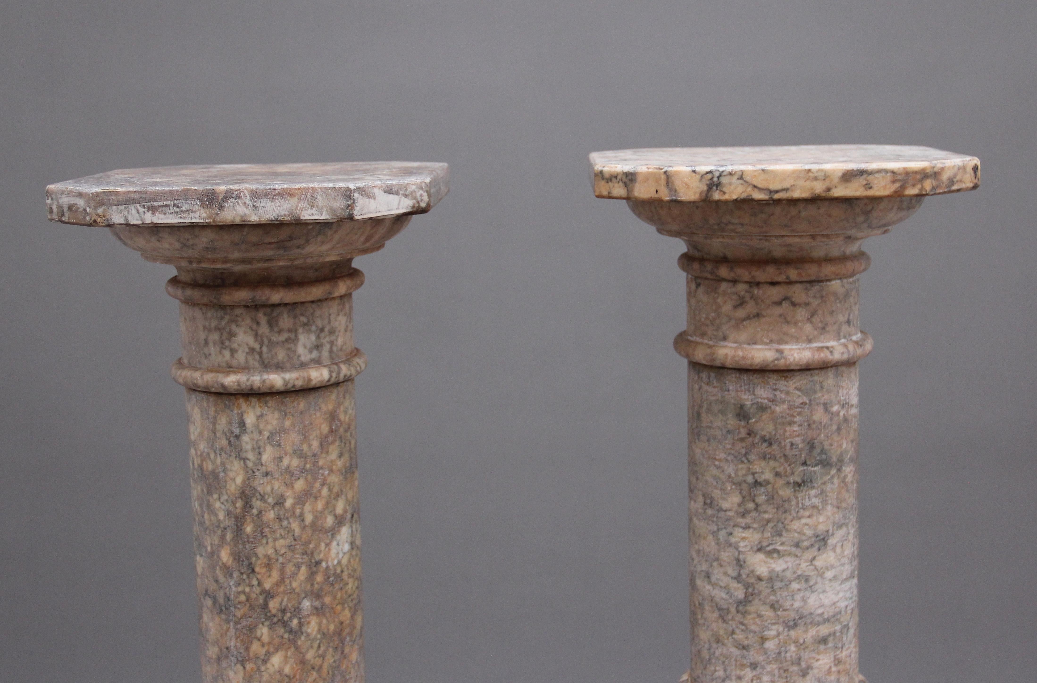 Ein hochdekoratives Paar italienischer Alabaster-Sockelsäulen aus dem frühen 20. Jahrhundert in fantastischem Zustand und mit auffälligen Farben. Die Säulen haben eine achteckige Spitze über Kanonenrohrsäulen mit geschnitzter Dekoration, die auf