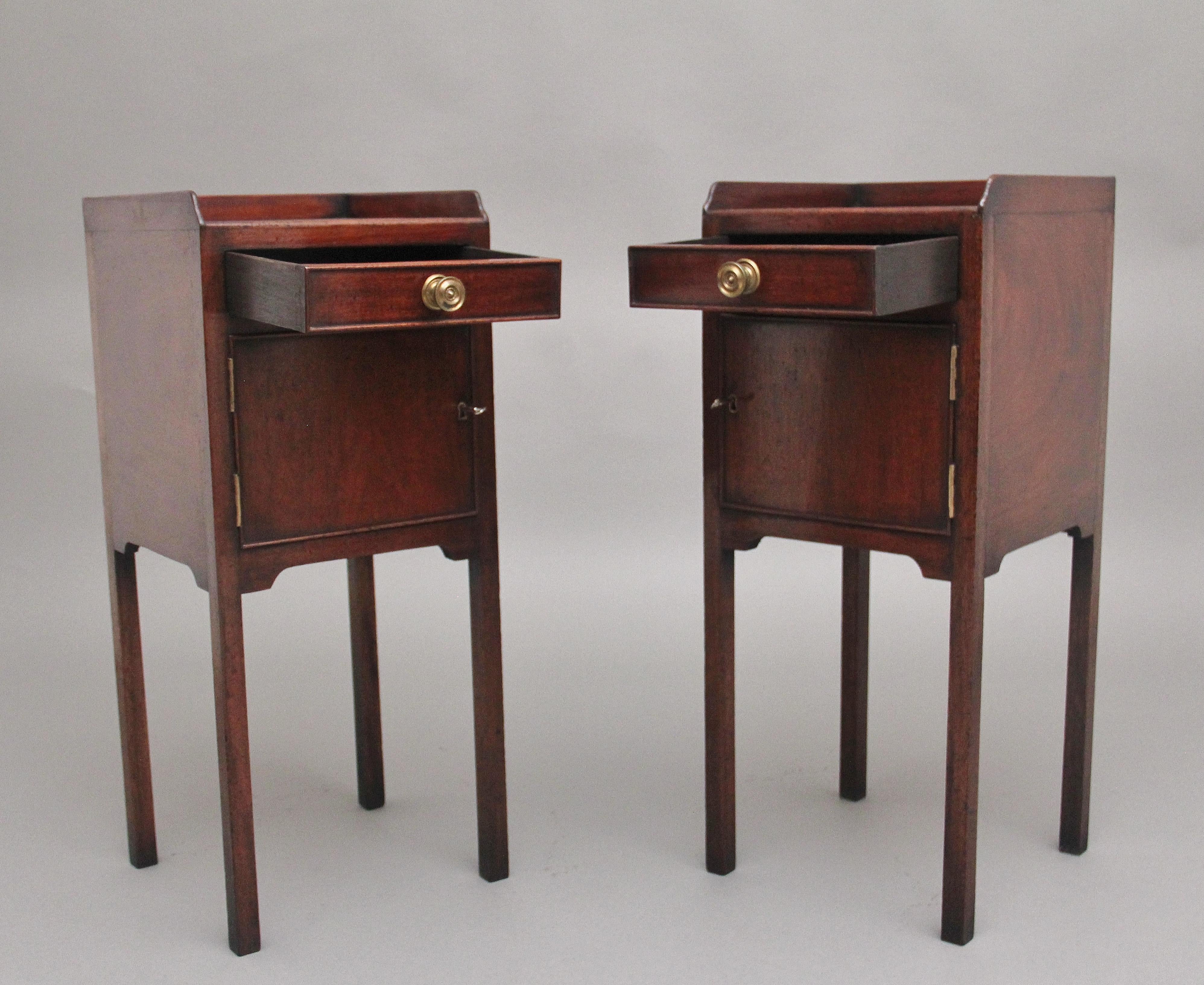 A nice pair of early 20th Century mahogany bedside cupboards, the tops having a three quarter gallery above a single oak lined drawer with the original brass turned engraved handle, a hinged cupboard door opening to reveal a large compartment space,
