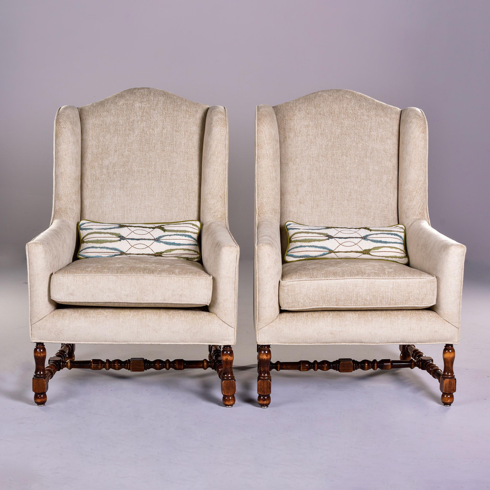 Pair of circa 1920s tall French winged armchairs with turned legs and stretchers, new off sand colored chenille velvet upholstery and coordinating separate lumbar cushions in Pindler fabric. Unknown maker - sold and priced as a pair. 


Measures: