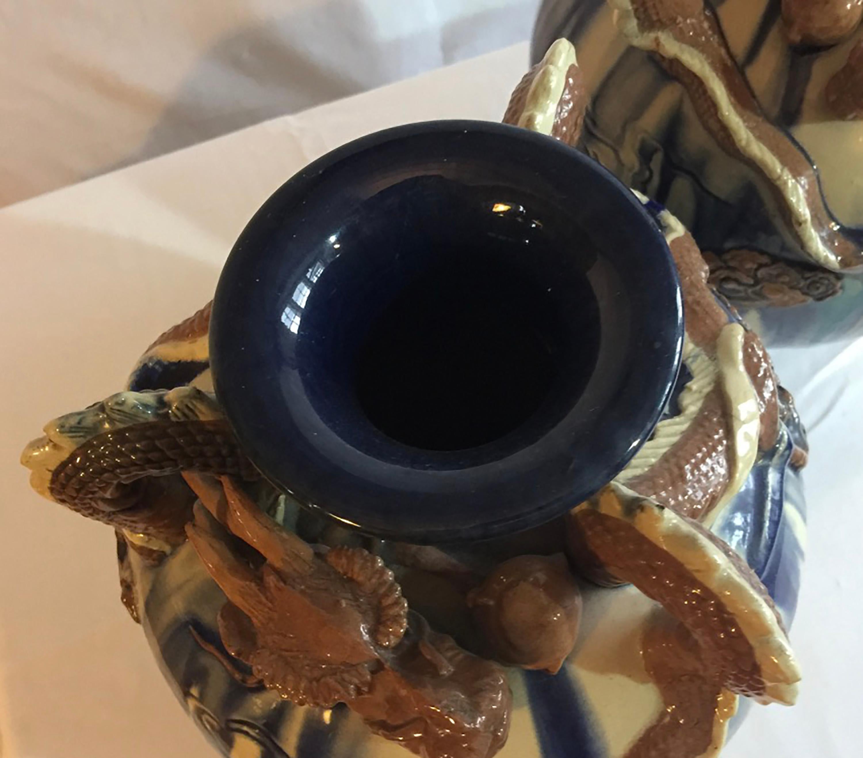 Early 20th century oriental inspired blue and white spherical Art Pottery vases with dragons and experimental drip glaze. These are are in almost perfect condition and have three feet and no makers mark. Included are details of the feet showing the