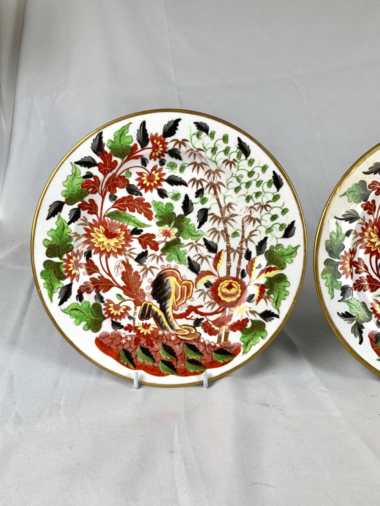 Dieses exquisite Paar früher Minton-Porzellanteller wurde um 1805 in England hergestellt und zeigt wunderschön handgemalte orientalische Blumen und Bambuszweige in leuchtenden Rot-, Gelb-, Grün- und Grautönen.
Ein Teil des komplizierten Musters