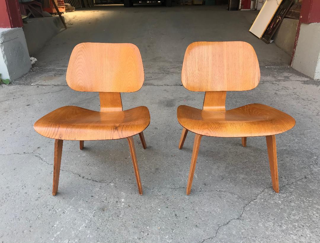 Stunning pair of early production Eames L C W's, 5-2-5- screw configuration, designed by Charles and Ray Eames, amazing wood grain, Classic modernist lounge chairs.