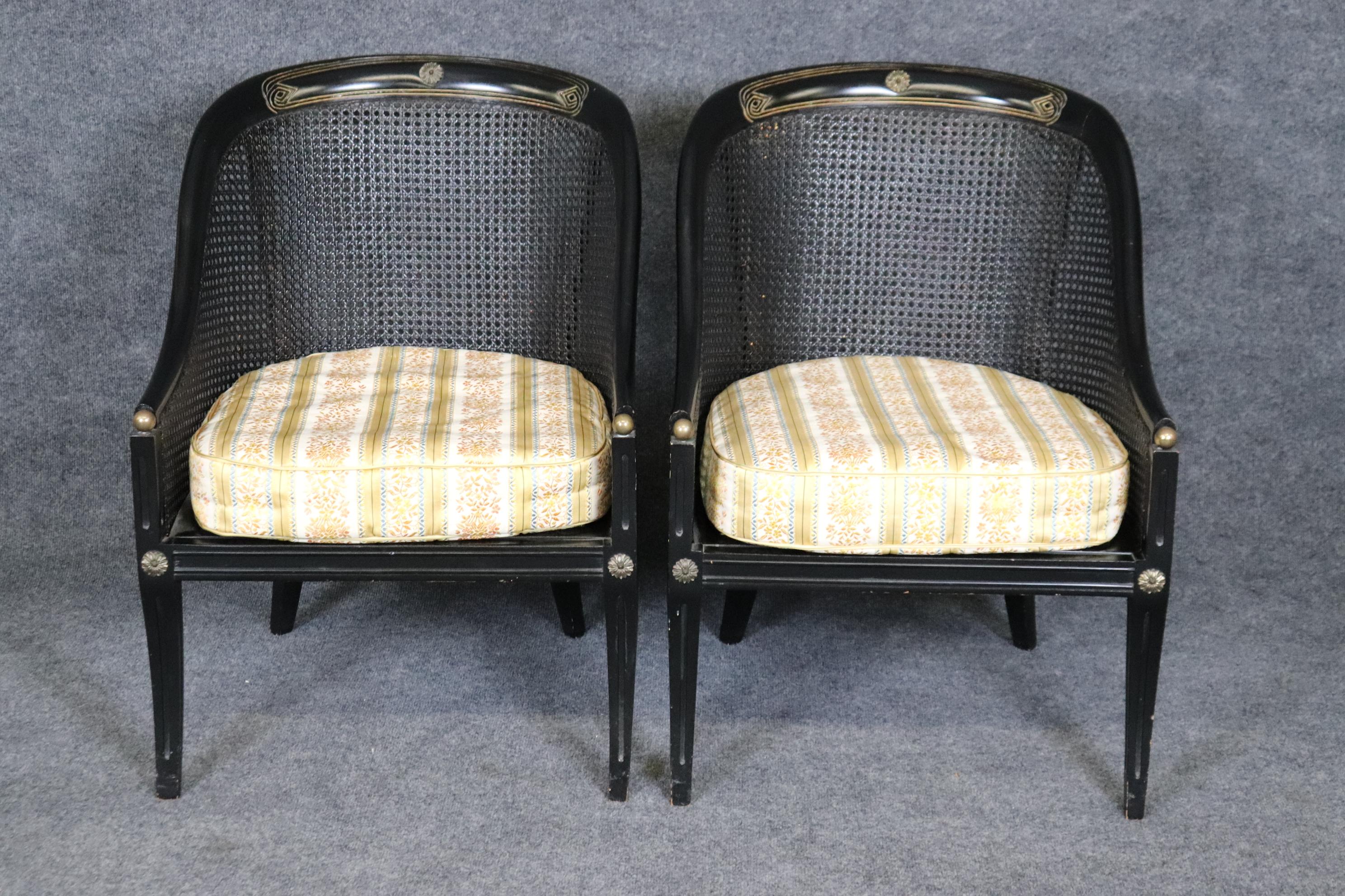 This is a stylish pair of Directoire style cane chairs with gilt and ebonized frames. The chairs are in good condition with minor signs of damage to the cane as shown which is extremely minor and not seriously damaged. The chairs are absolutely