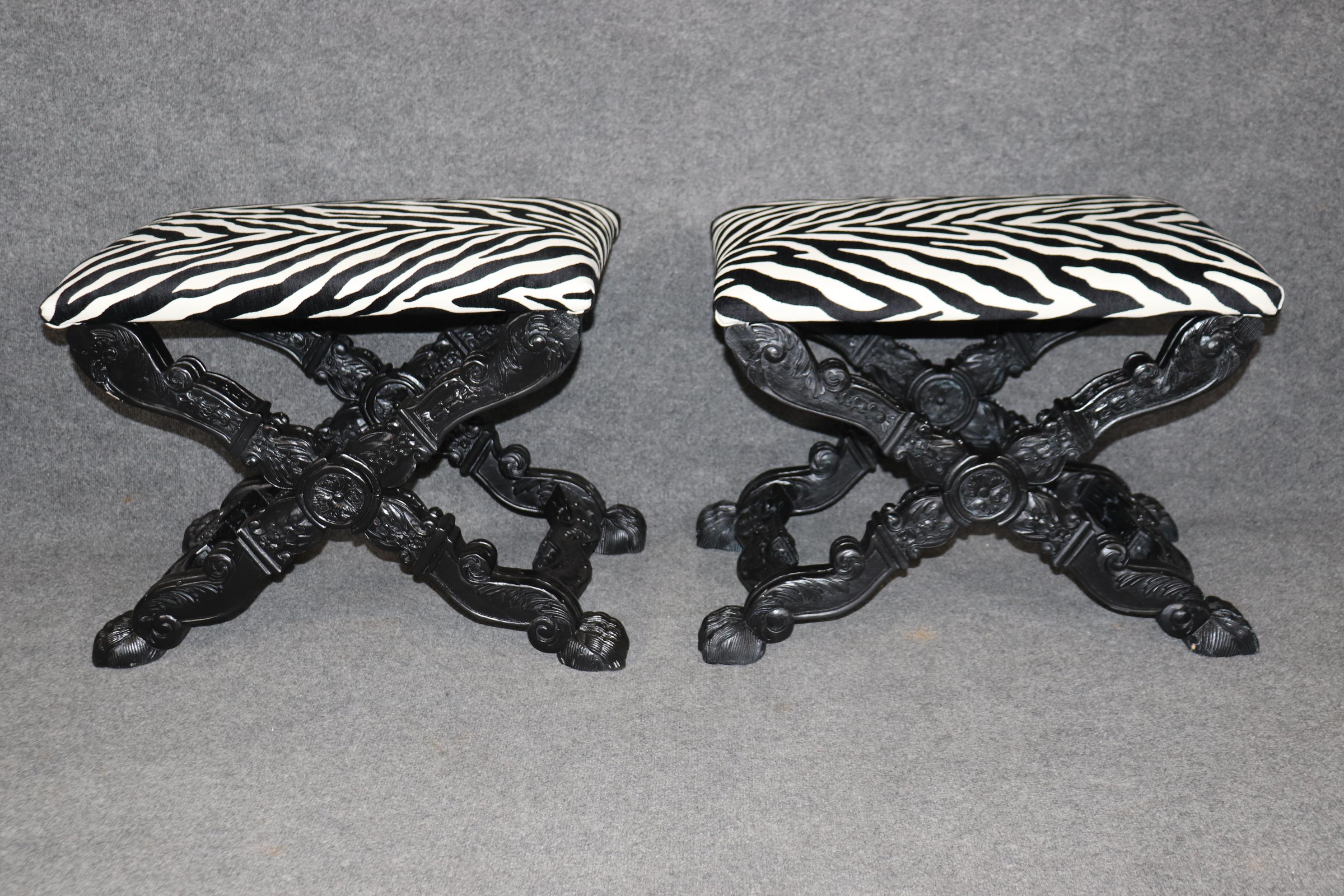 This is a fantastic pair of zebra printed upholstered benches or stools in the French Regency manner. They are designed in the Maison Jansen style with robust carved frames and ebonized finish. The stools are in good condition with only minor signs