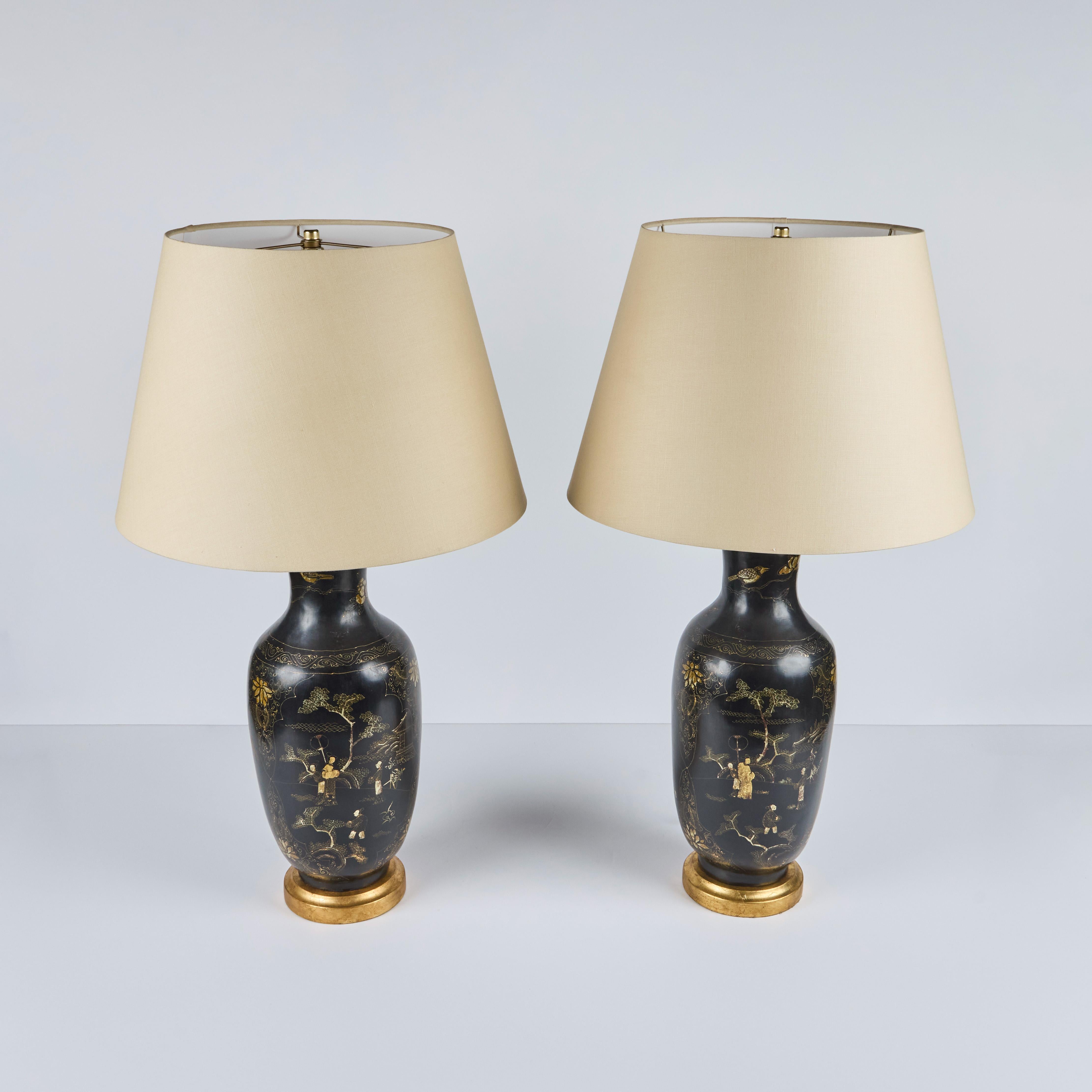 Ein Paar englische Vasen aus ebonisiertem Holz mit handgemaltem Chinoiserie-Dekor, ca. 1950, als Lampen aus späterer Zeit auf vergoldeten Holzsockeln.  
Neue hellbraune gewebte Farbtöne. 
