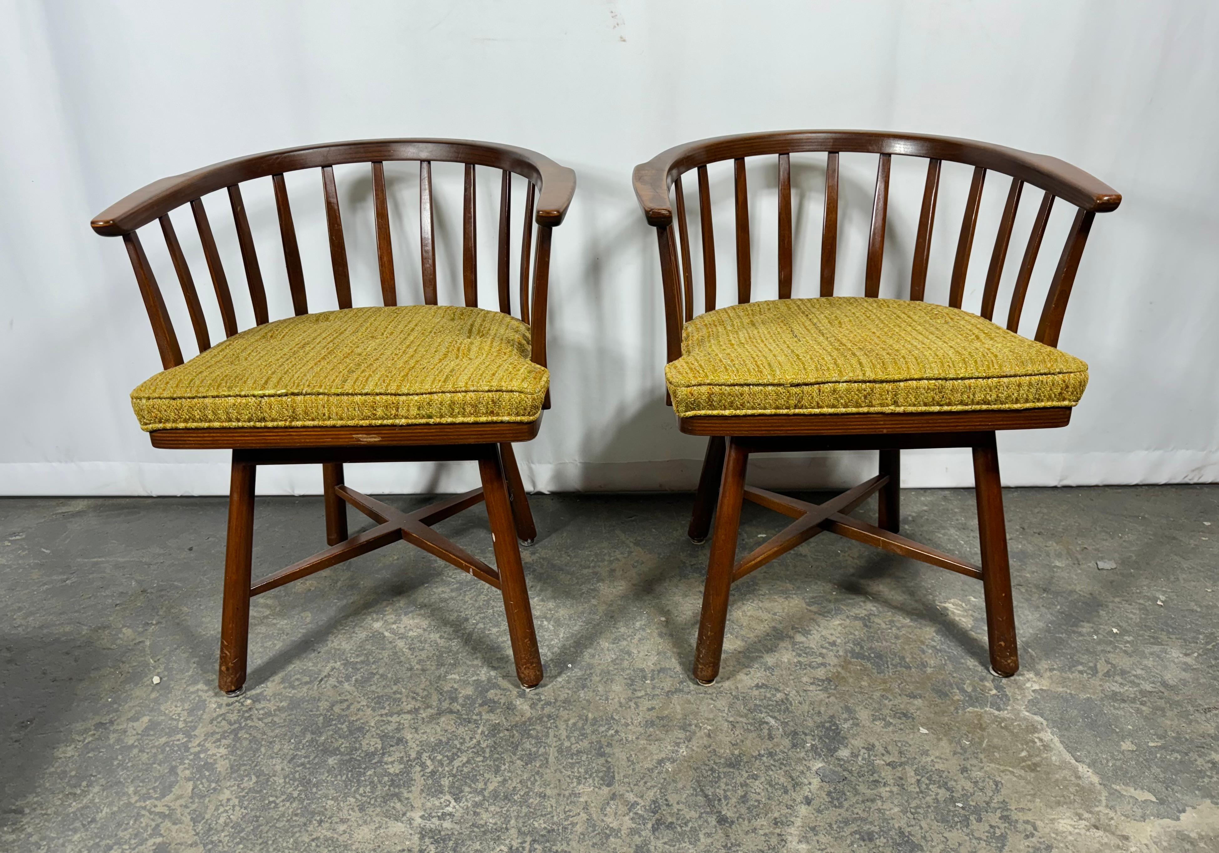 Seldom seen matched pair of Edward Wormley/ Dunbar Swivel Chairs, laminated flat spindles, seat and crest rail with, X base with solid walnut tapered legs.
Chairs retain they're original finish,original fabric upholstery, 
 they're original Brass