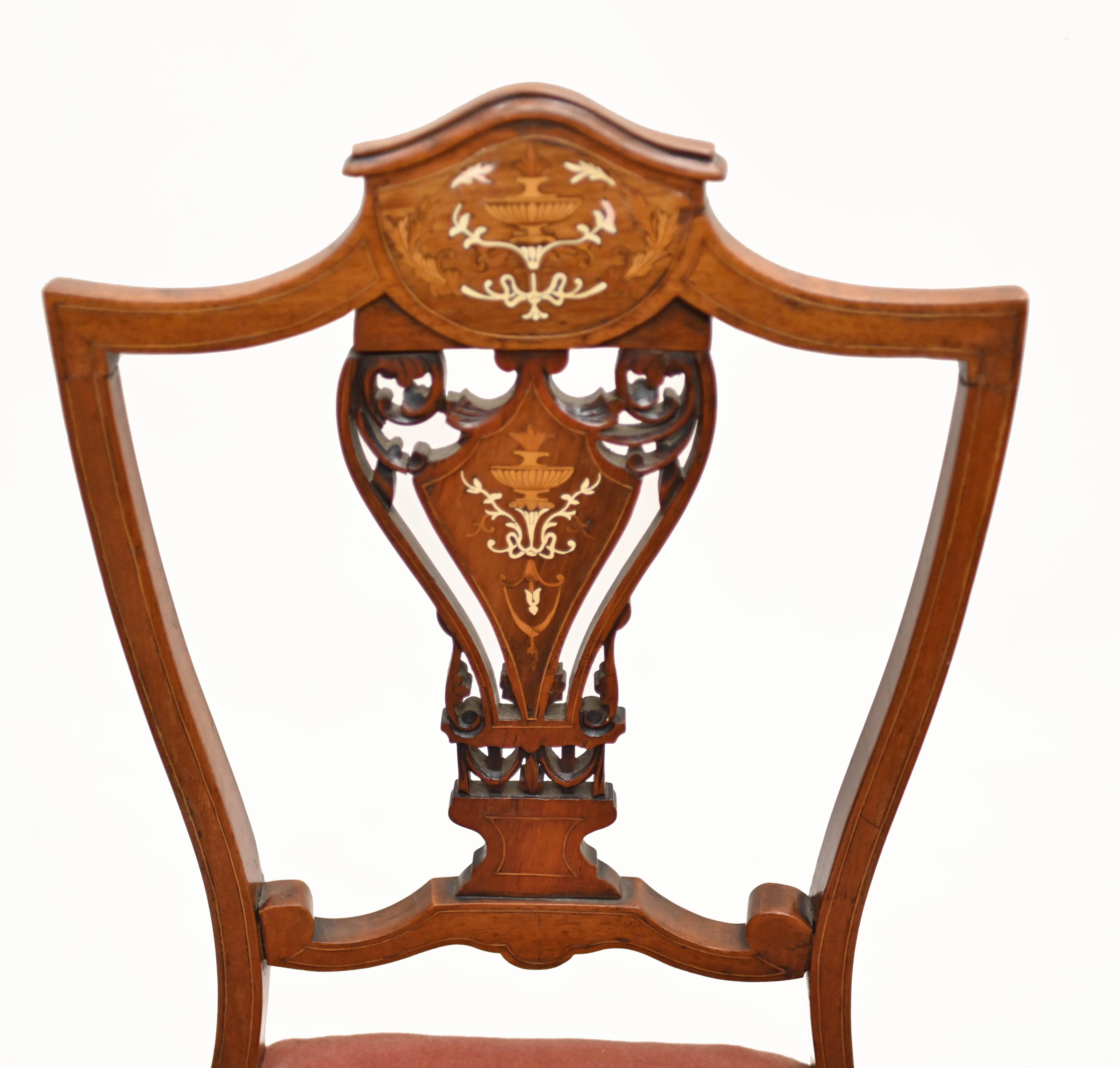 Quality pair of Edwardian inlayed hall chairs in mahogany
We date this lovely pair of accent chairs to circa 1910
Back rest - with shield back - features intricate inlay work including classical urns and floral motifs
Purchased from a private