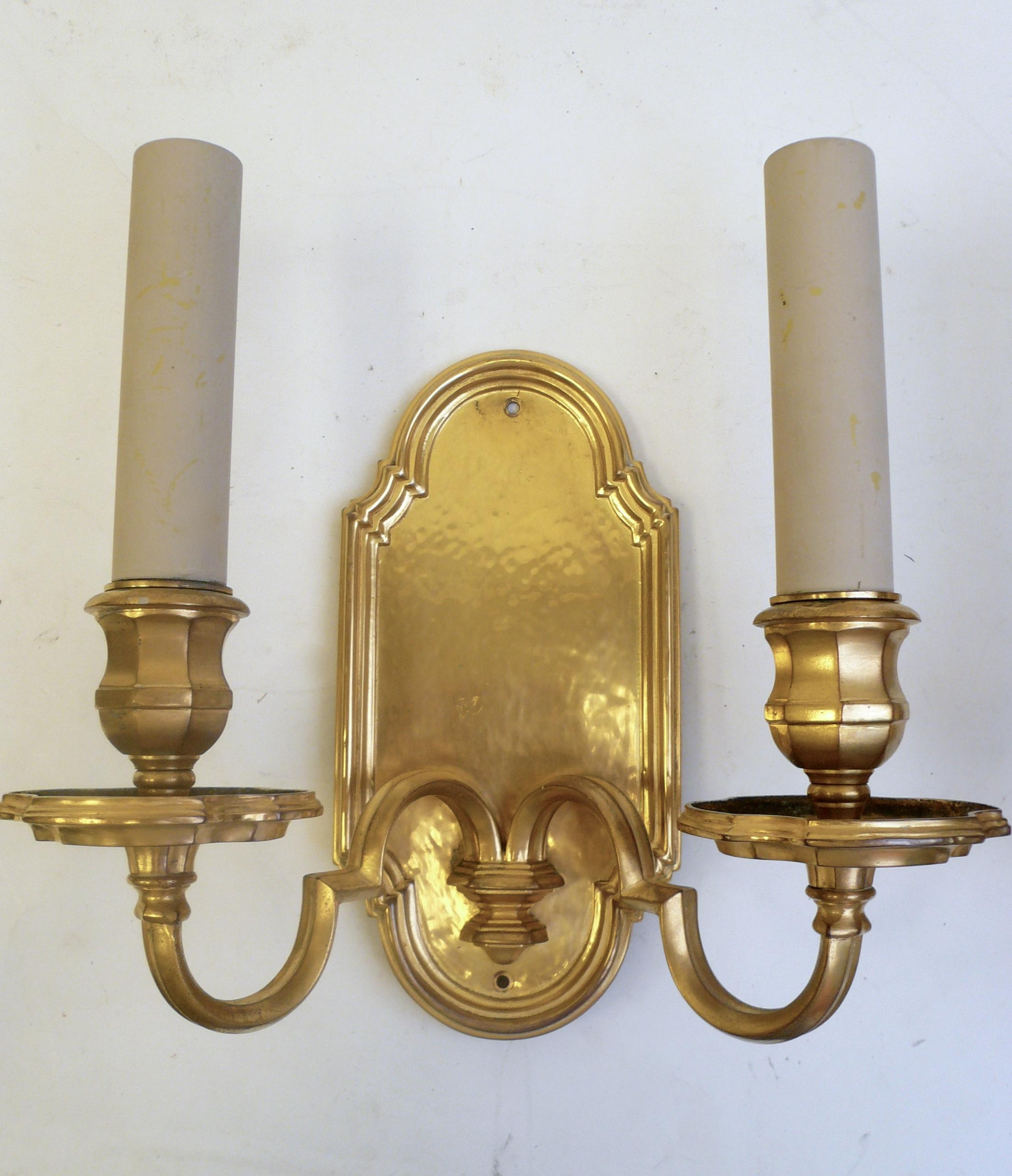 This handsome pair of Old English style Caldwell sconces are finely detailed, and have a mellow gilt finish. Originally from the library of 
