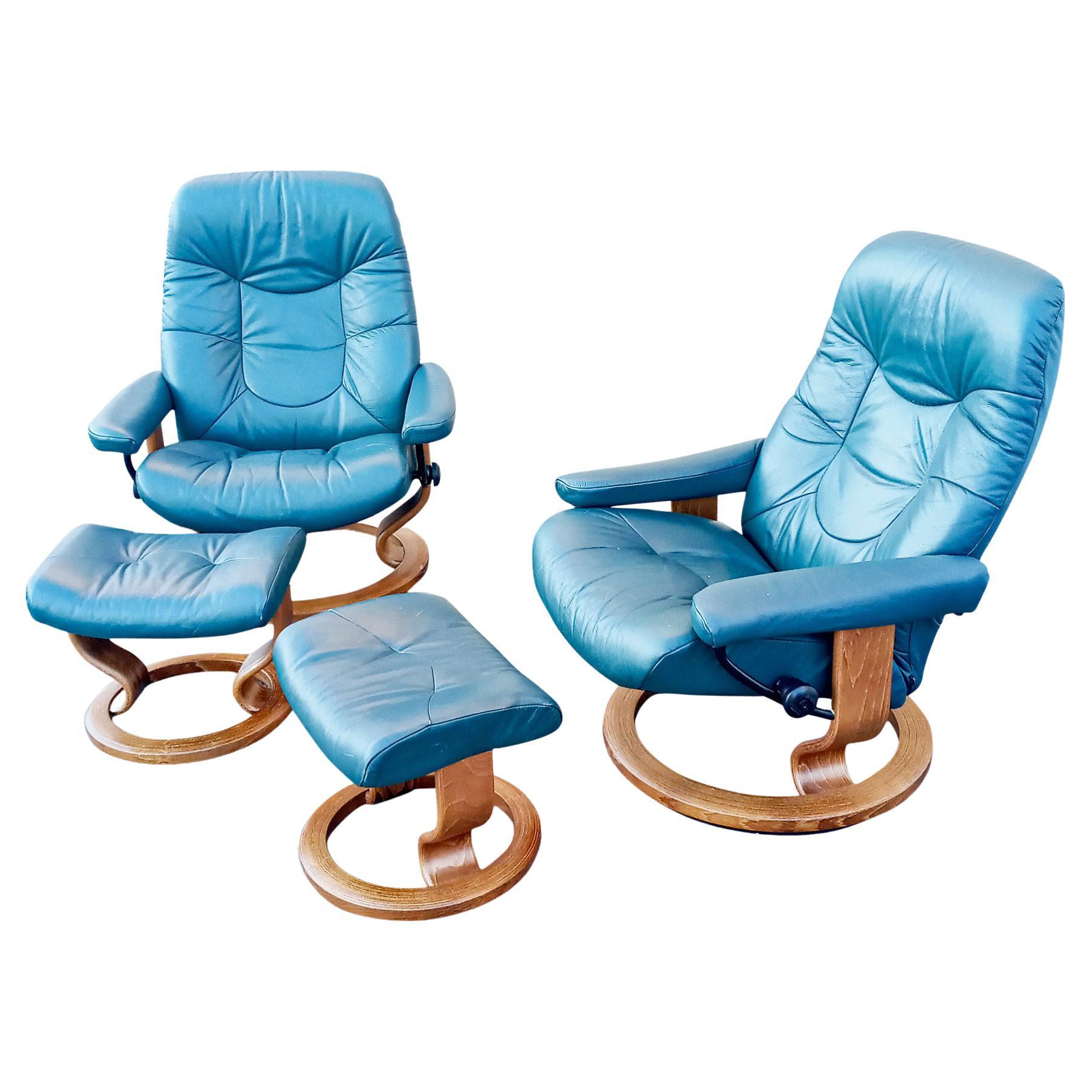 A Scandinavian style pair of recliners and ottomans by Ekornes, their Stressless brand. With teak wood and metal frames and genuine leather upholstery, these comfortable green/teal (not blue) color leather recliners on a round teak wood bases that