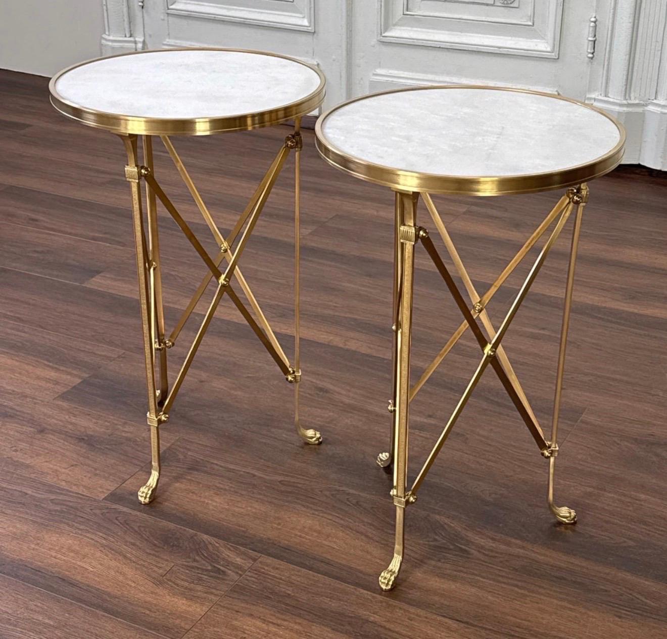 Paire de guéridons Empire en bronze et marbre, France, années 1950.
Chaque table d'appoint est dotée d'un plateau en marbre de Carrare blanc avec moulures circulaires, de pieds en X et de pieds pattes, d'une hauteur de 26,5 pouces et d'un diamètre