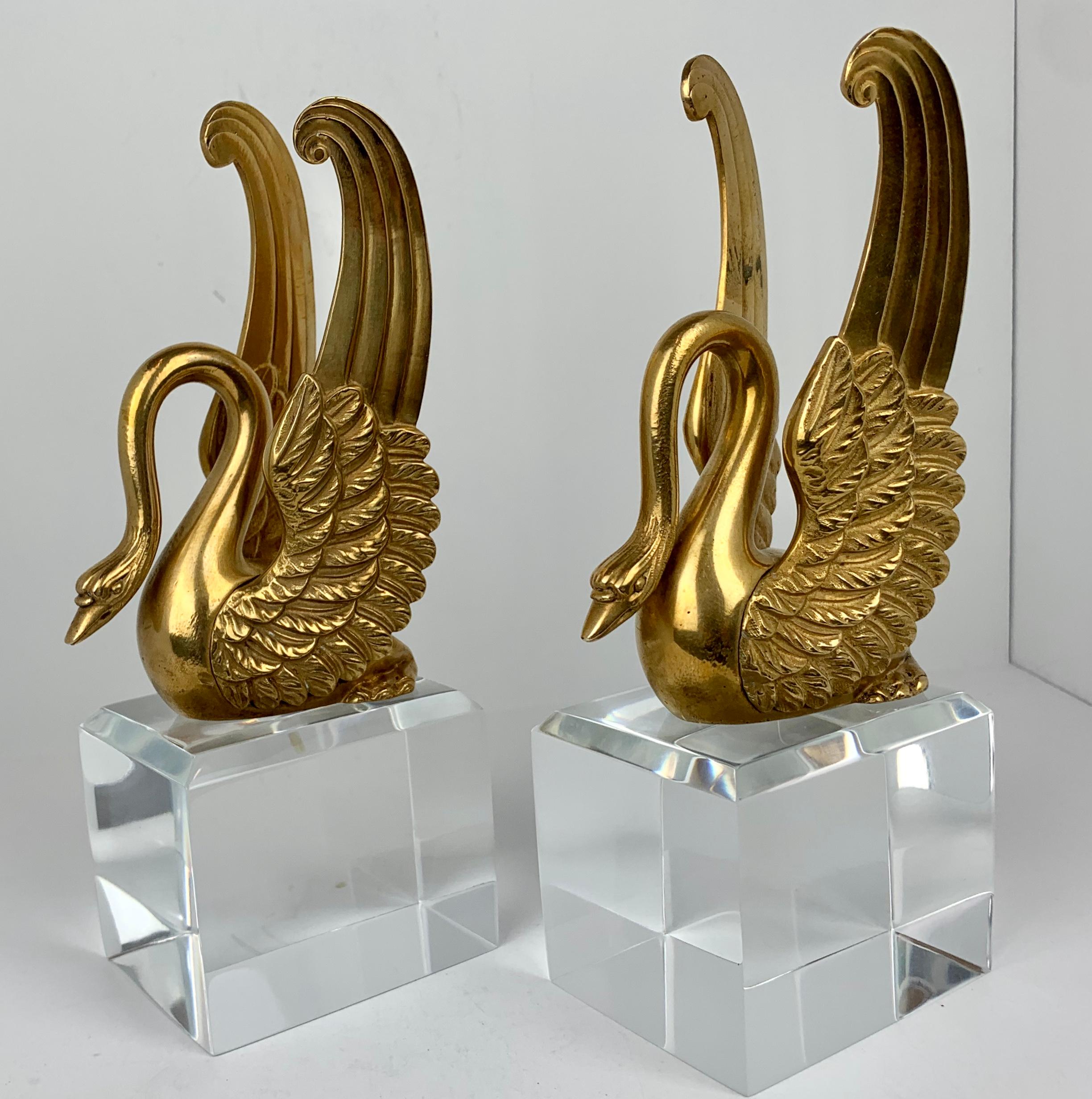 Pair of nineteenth century Empire style well modeled bronze doré swans with their wings folded back. They are well chased and now custom mounted on beveled Lucite plinths. One wing on one swan has a wing very slightly bent inward.
Measures: The