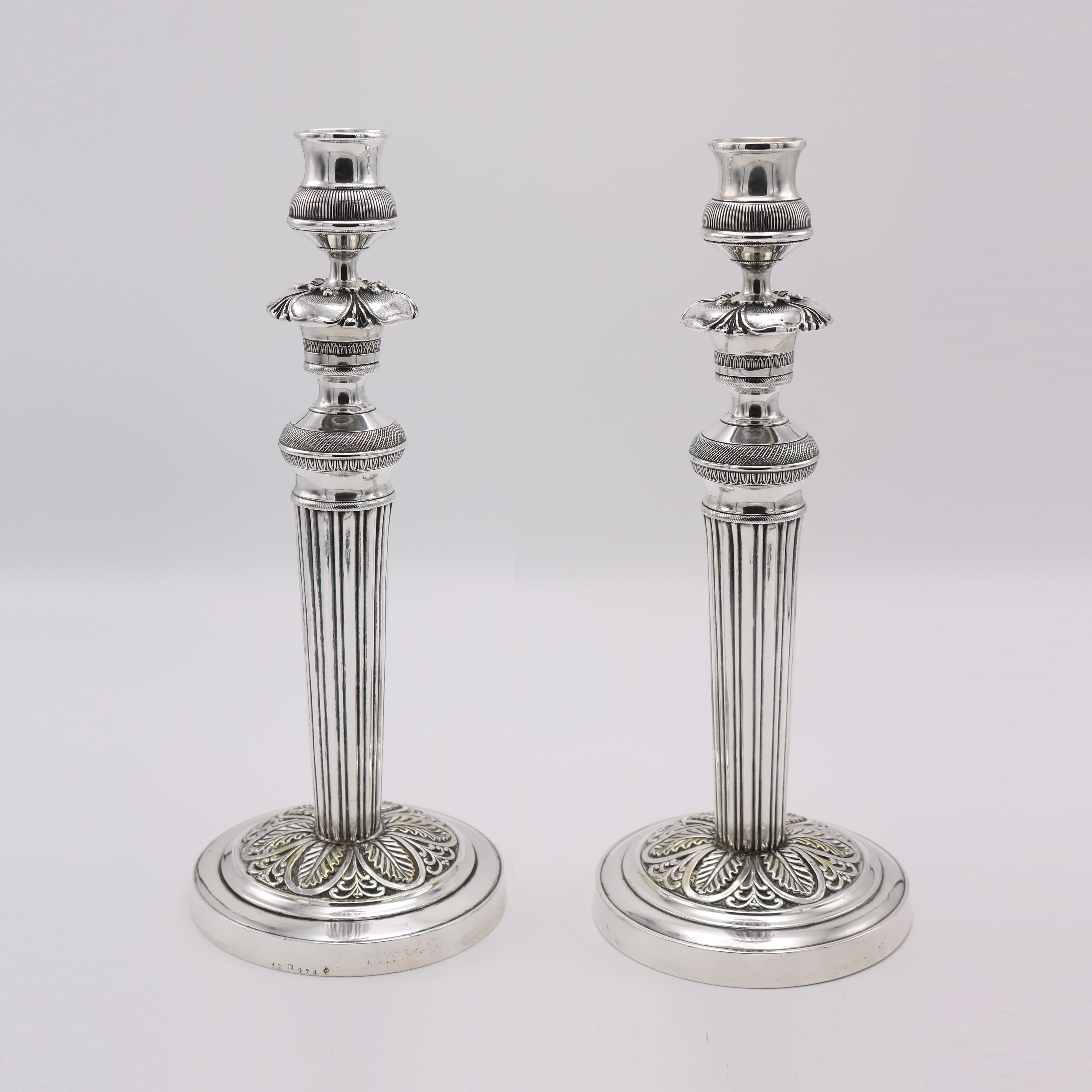 A pair of French Empire period candlesticks from France circa 1820. The base with a border of stylized palmettes supporting fluted columns , Hollow cast brass and silverplate.
