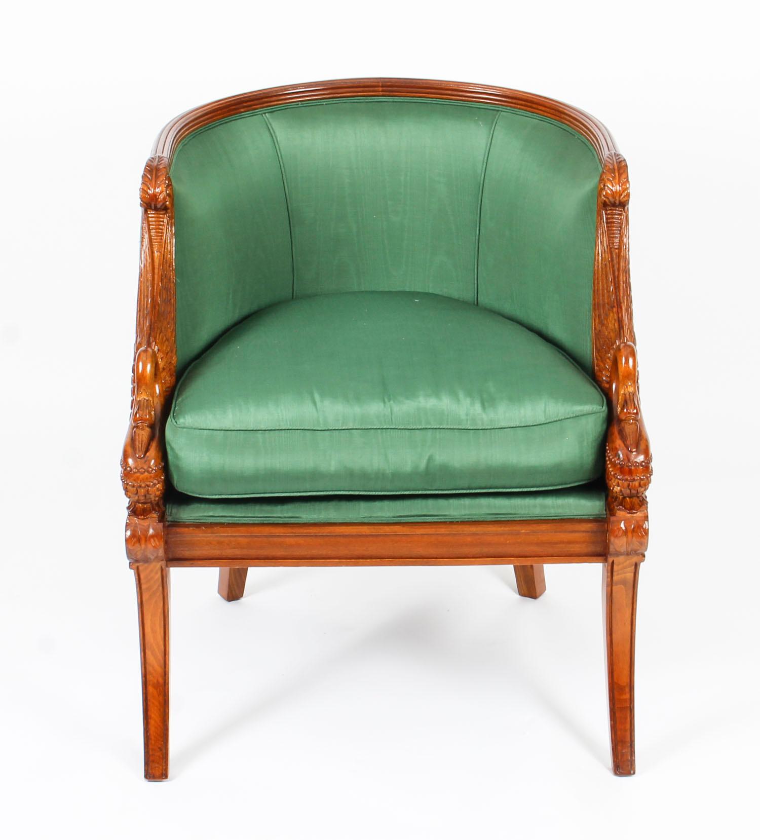 This is a wonderful pair of hand carved solid walnut French Empire Revival armchairs, dating from the second half of the 20th century.

They have beautifully carved swan armrests and raised on front sabre legs.

They are beautifully upholstered in