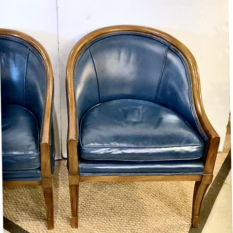 This is an outstanding example of an empire-style bergere that was created by Karges Furniture c. 1980. The bergeres are beautifully upholstered in a richly muted French blue leather. The frames are of solid walnut and in an unadorned Empire,
