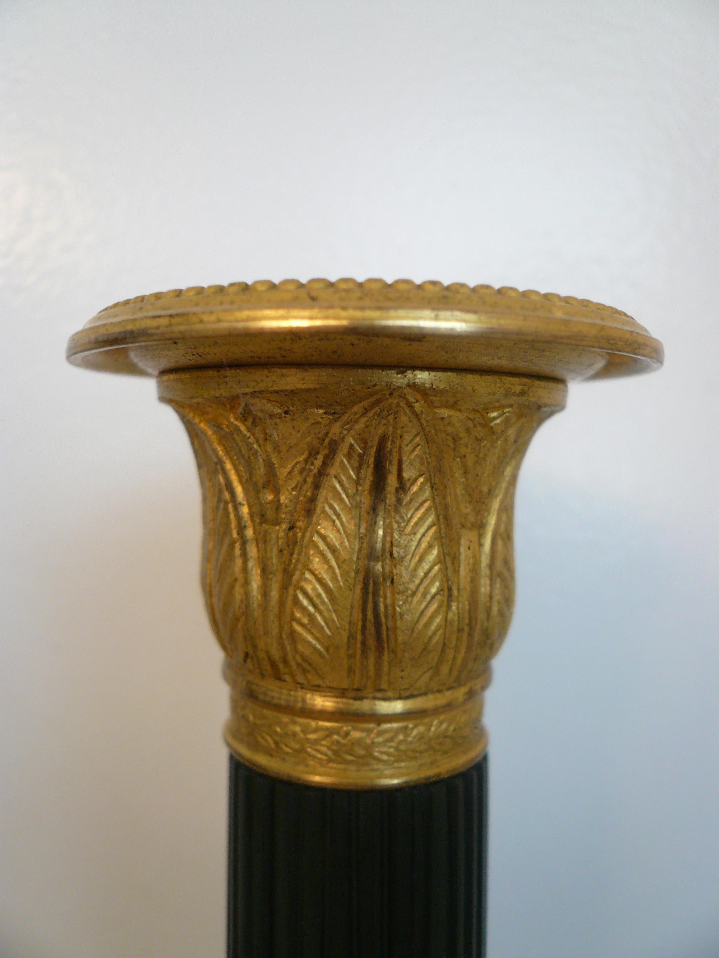 Dieses hübsche Paar Kerzenleuchter aus Bronze zeigt klassische Motive wie Akanthusblätter und geriffelte, spitz zulaufende Schäfte.