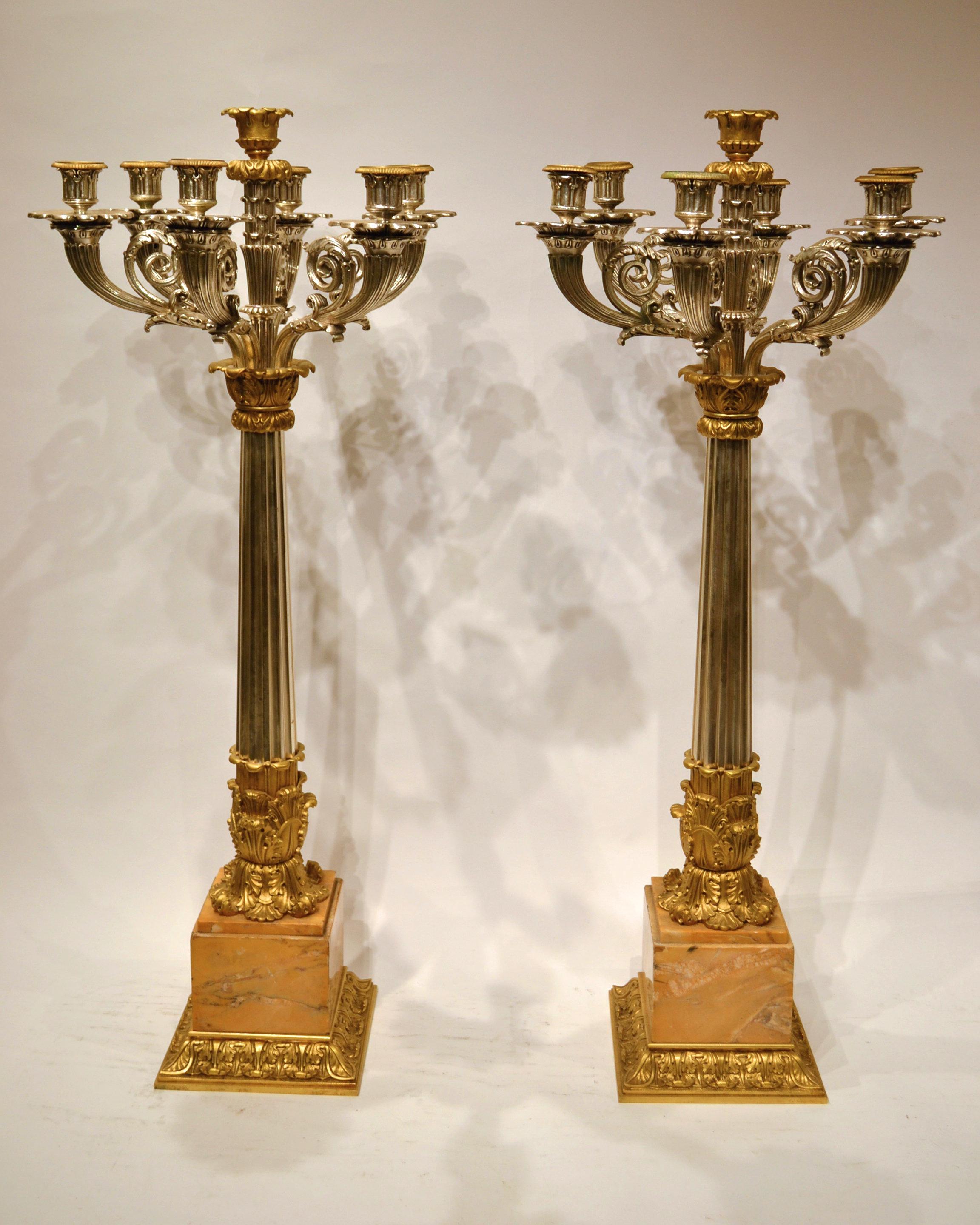 Zwei sehr große französische Kandelaber im Empire-Stil des 19. Jahrhunderts aus versilberter und vergoldeter Bronze mit Marmorsockeln.