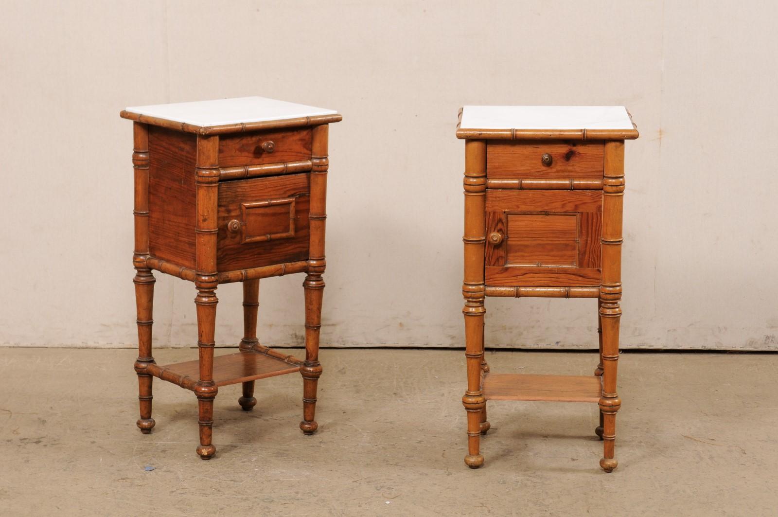 An English pair of side chests, with lower shelf and marble tops, from the early 20th century. These antique side chests from England are each topped with white marble slabs, resting atop a case which houses a small drawer over a single recessed
