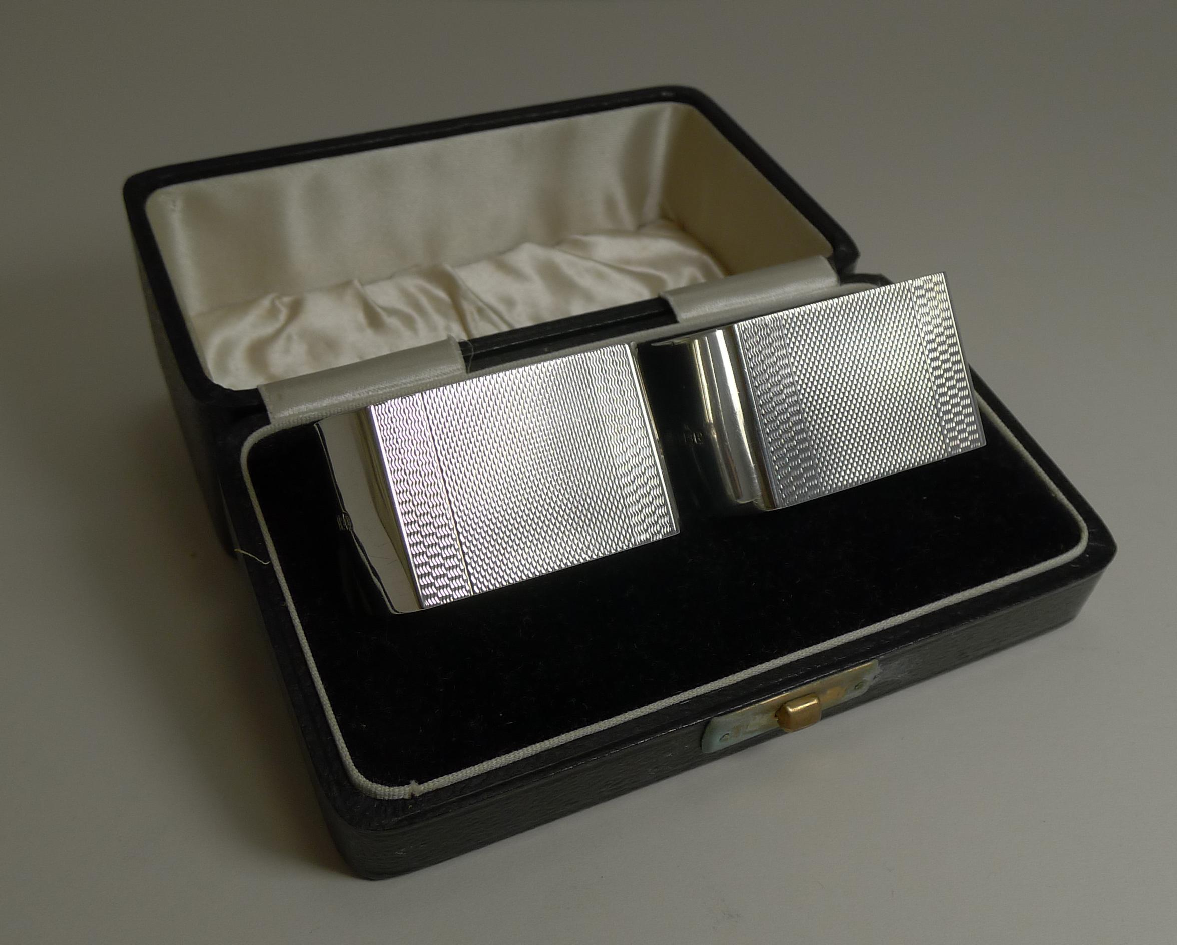A fabulous and very smart pair Art Deco napkin rings in pristine condition complete in their original presentation box.

Made from English sterling silver, they have engine turned decoration to both back and front and each with plain shaped sides.