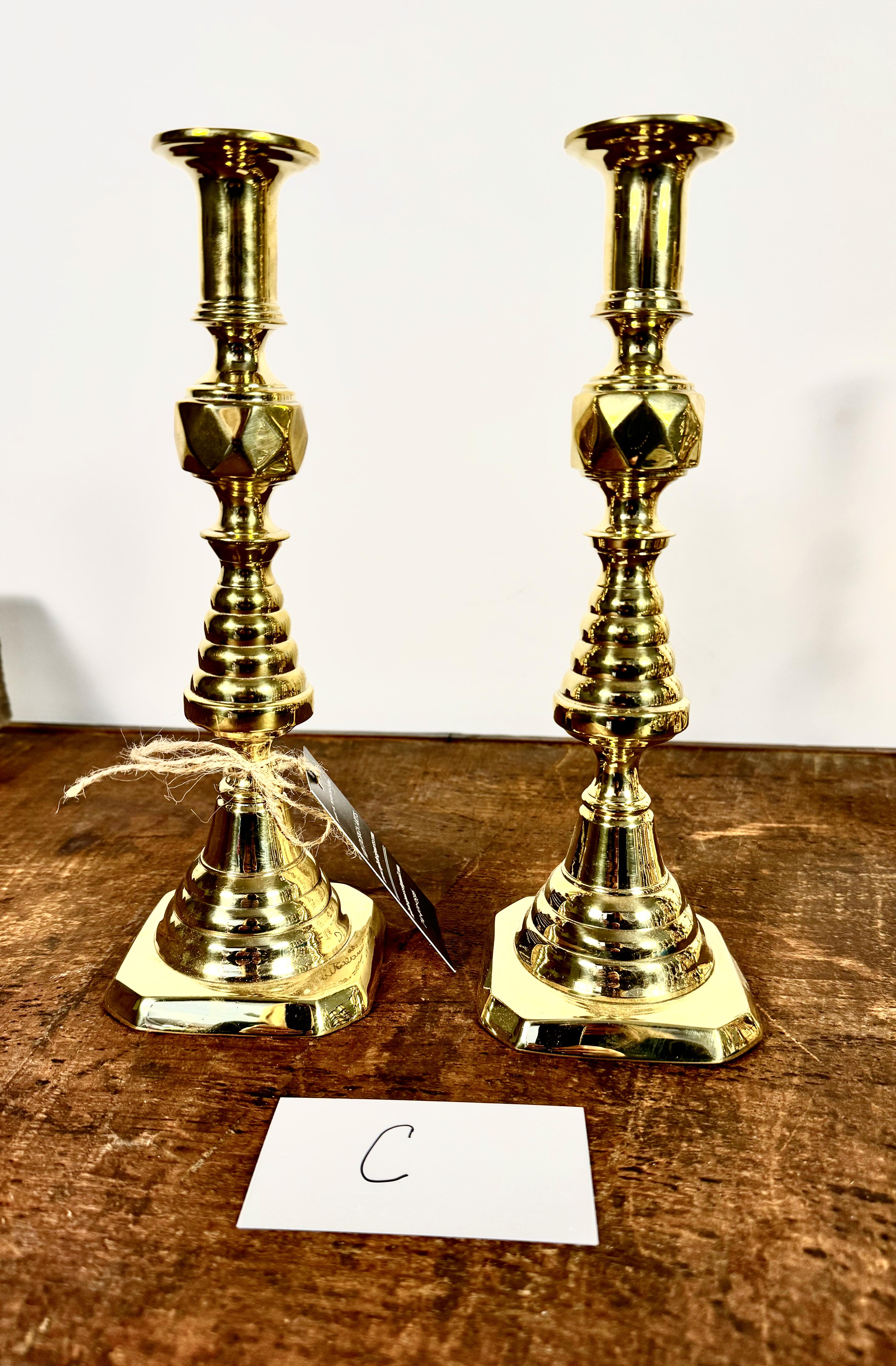 This is a pair of iconic tall English Victorian Inverted Beehive & Diamond Candlesticks that dates to c. 1860 - 1870. English brass candlesticks were both utilitarian and decorative being necessary objects in every home from the wealthiest to the
