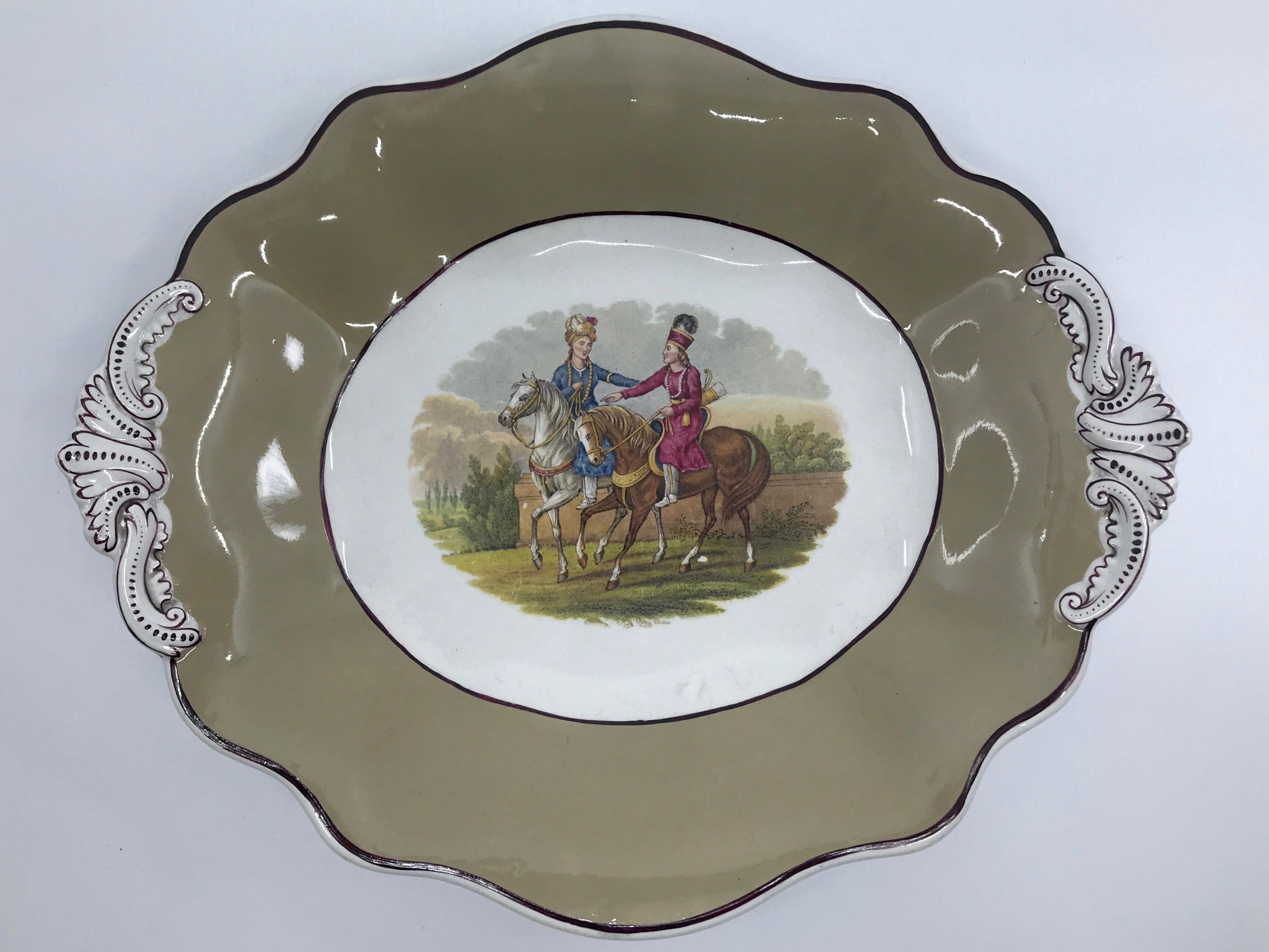 Pair English exotic equestrian serving dishes. Pair mocha and Bordeaux banded and shaped serving dishes/trays centering two equestrian groupings; one with mounted ottomans in fancy dress on two horses in front of a walled landscape, the other