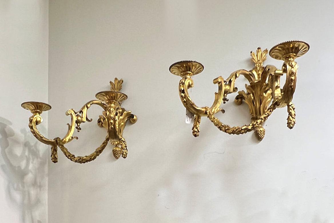 Our large, ormolu bronze wall appliques in the Georgian style candle arms in the shape of c-scrolls with acanthus leaf and bellflower motifs and swags, emanating from backplates surmounted with feather plumes with acanthus leaf and scrolling