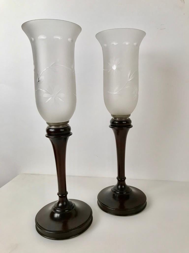 A fine pair of English Edwardian turned mahogany hurricane lamps with frosted glass removable shades etched with floral decoration. These have an elegant slender profile, the bases are weighted for stability.
17 inches high 5.25 diameter