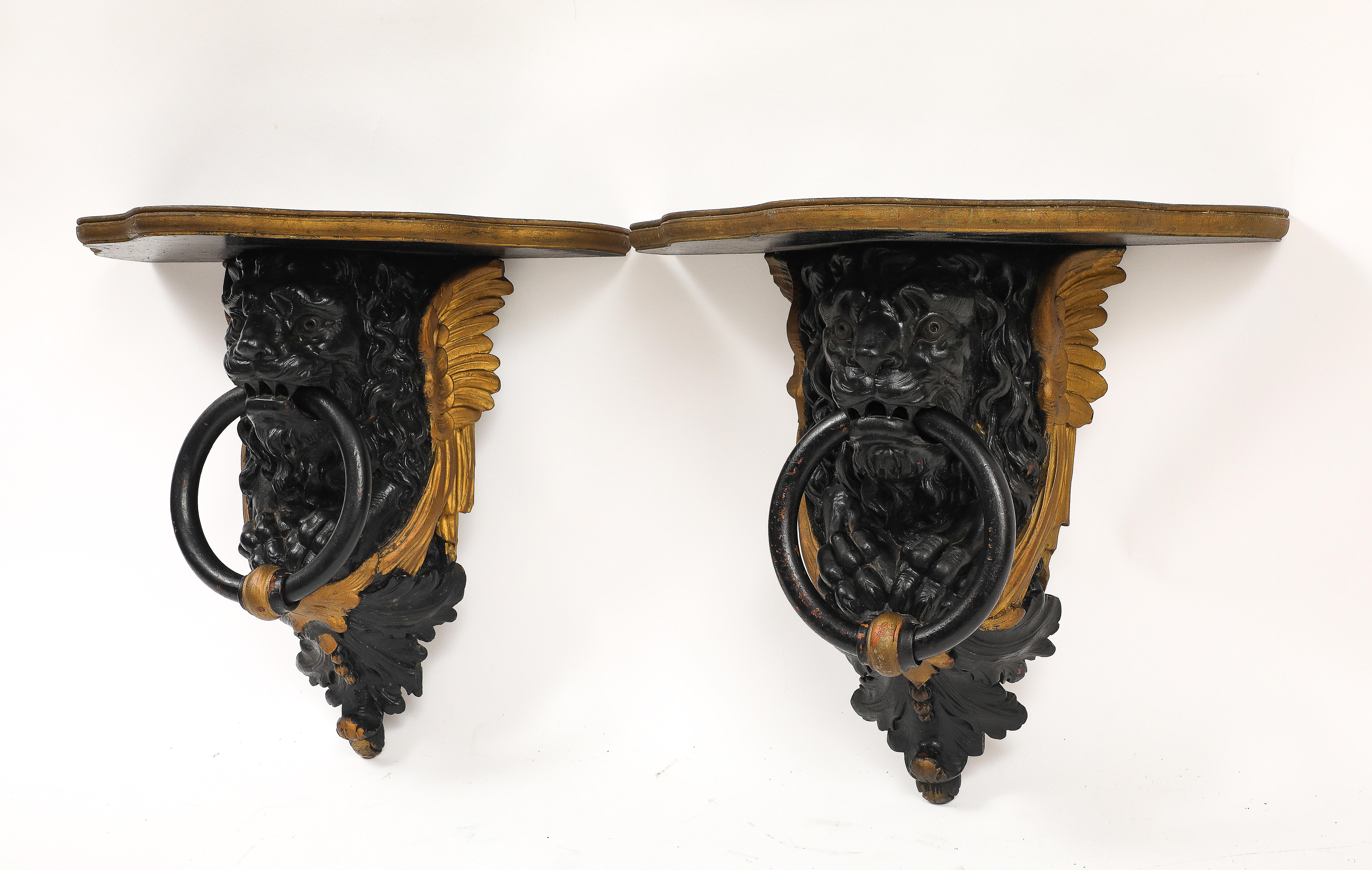 Inglese Coppia di mensole da parete inglesi Regency in lacca nera e oro con maschere di leone e anelli in vendita