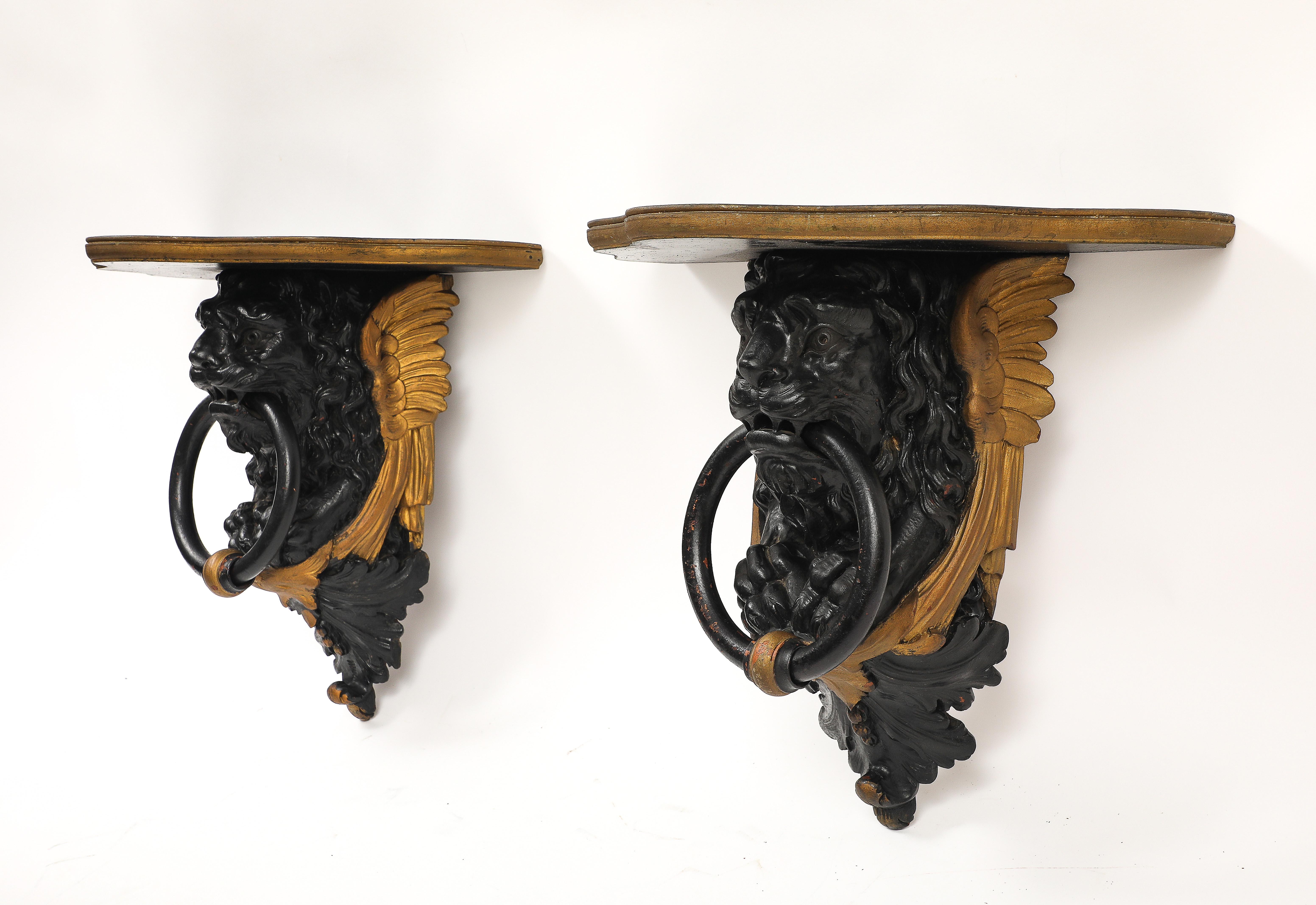 Coppia di mensole da parete inglesi Regency in lacca nera e oro con maschere di leone e anelli In condizioni discrete in vendita a New York, NY