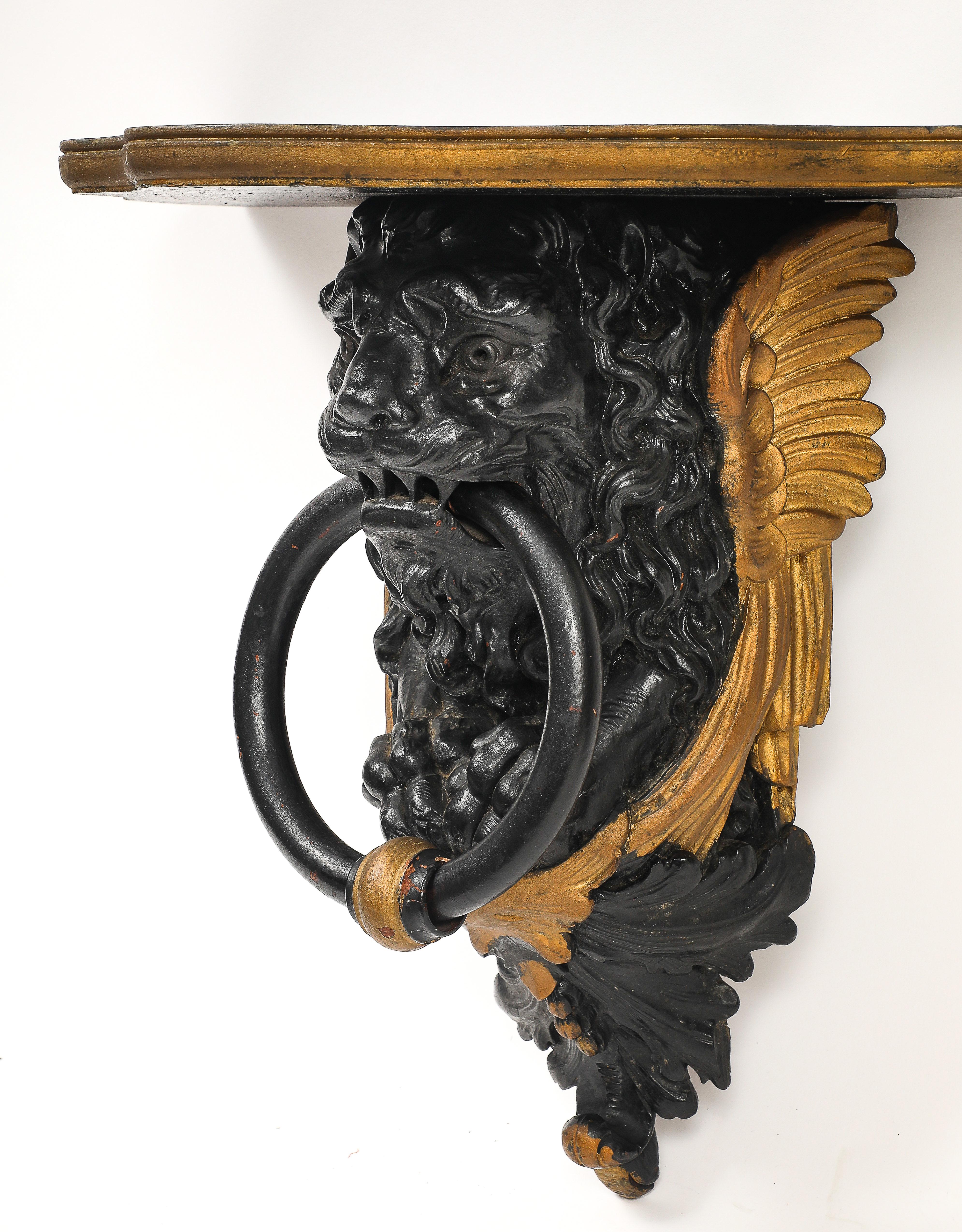 Coppia di mensole da parete inglesi Regency in lacca nera e oro con maschere di leone e anelli in vendita 1