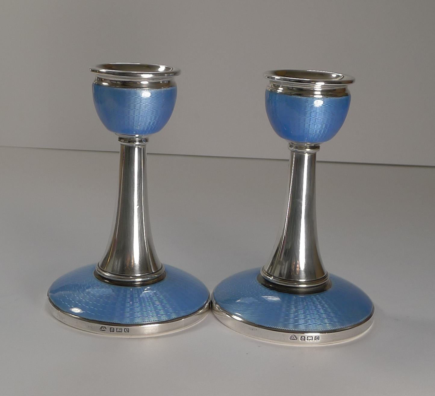 A stunning pair of Art Deco silver and guilloche enamel candlesticks each fully hallmarked for Birmingham 1927 together with the maker's mark for the well renowned silversmith's, Adie Brothers.

The beautiful blue enamel is bright and in superb