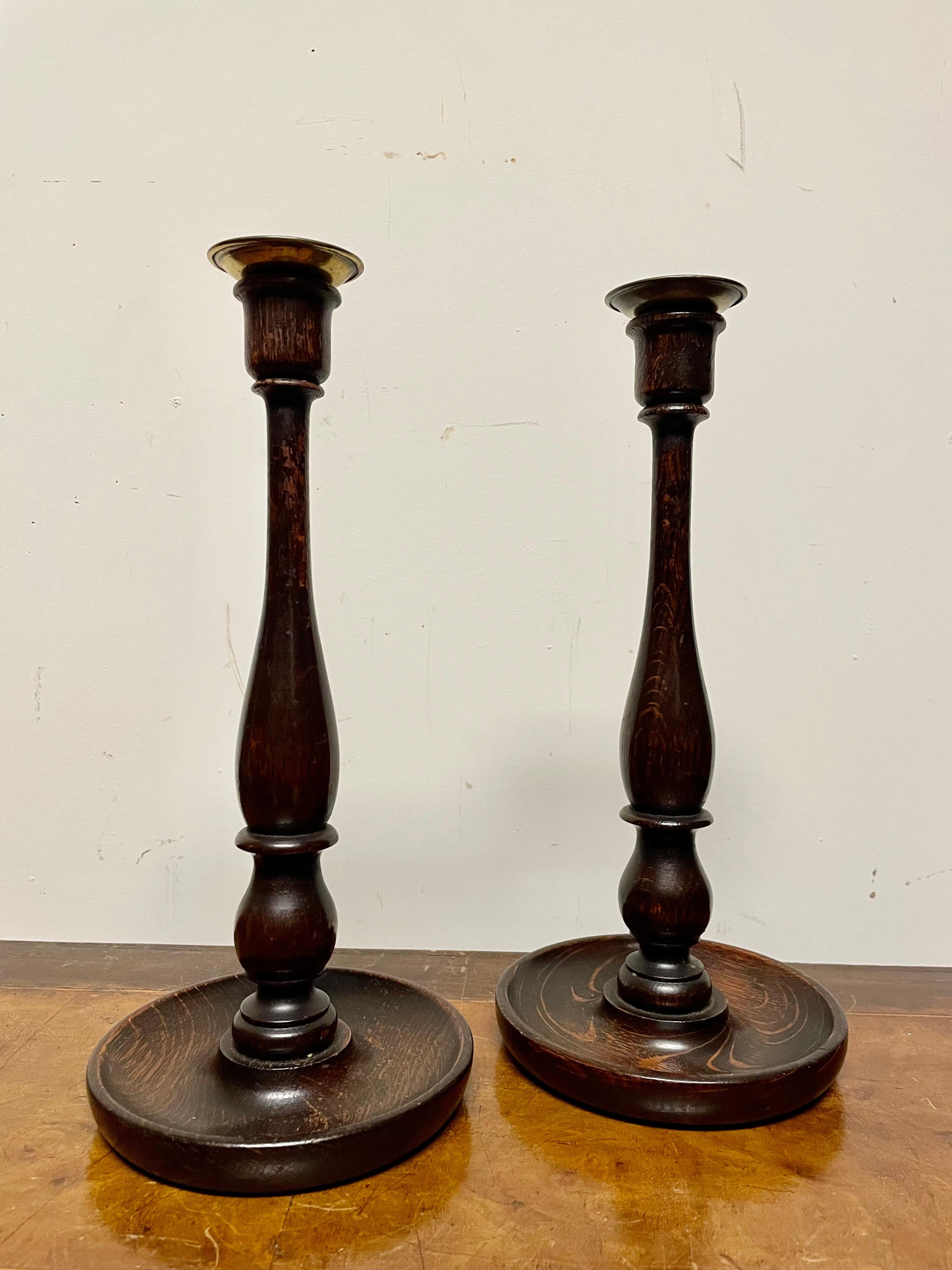 Pair of English Edwardian period hand turned Elm wood candlesticks with brass bobeche. Quite the handsome pair, reasonably priced, will make a great gift. 
Measures: 12 inches high, 5.75 diameter. 
Provenance: Phipps Family Estate, Long Island, NY.