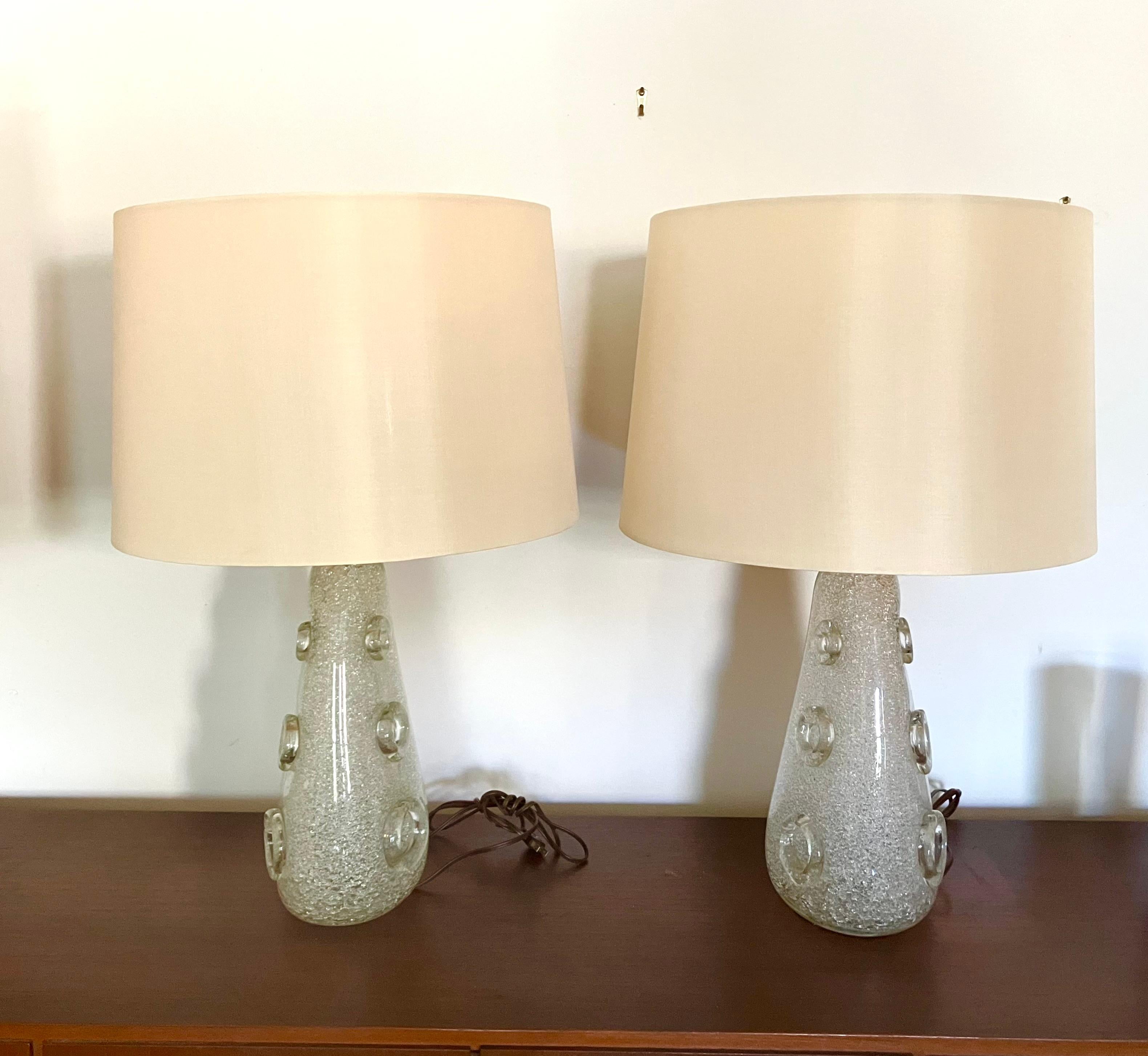 A rare pair of ‘Dew Glass’ table lamps, produced by Barovier & Toso. Ercole Barovier invented the Rugiada technique in 1938, and the process was patented and exclusive to the company. It involves the application of colorless glass grit and shards