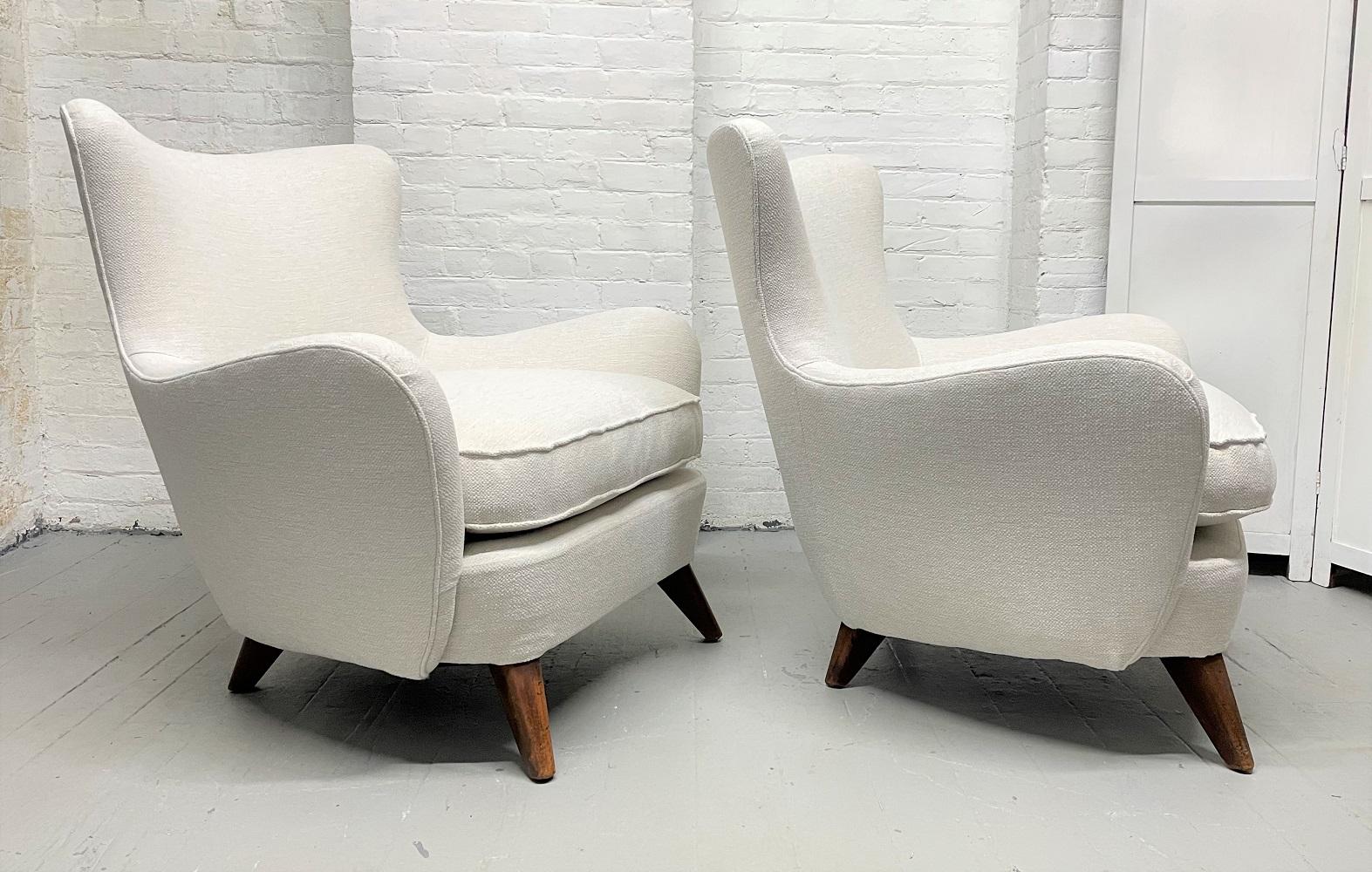 Pair of Ernst Schwadron lounge chairs. Nicely upholstered chairs with curved arms and solid wooden legs.
