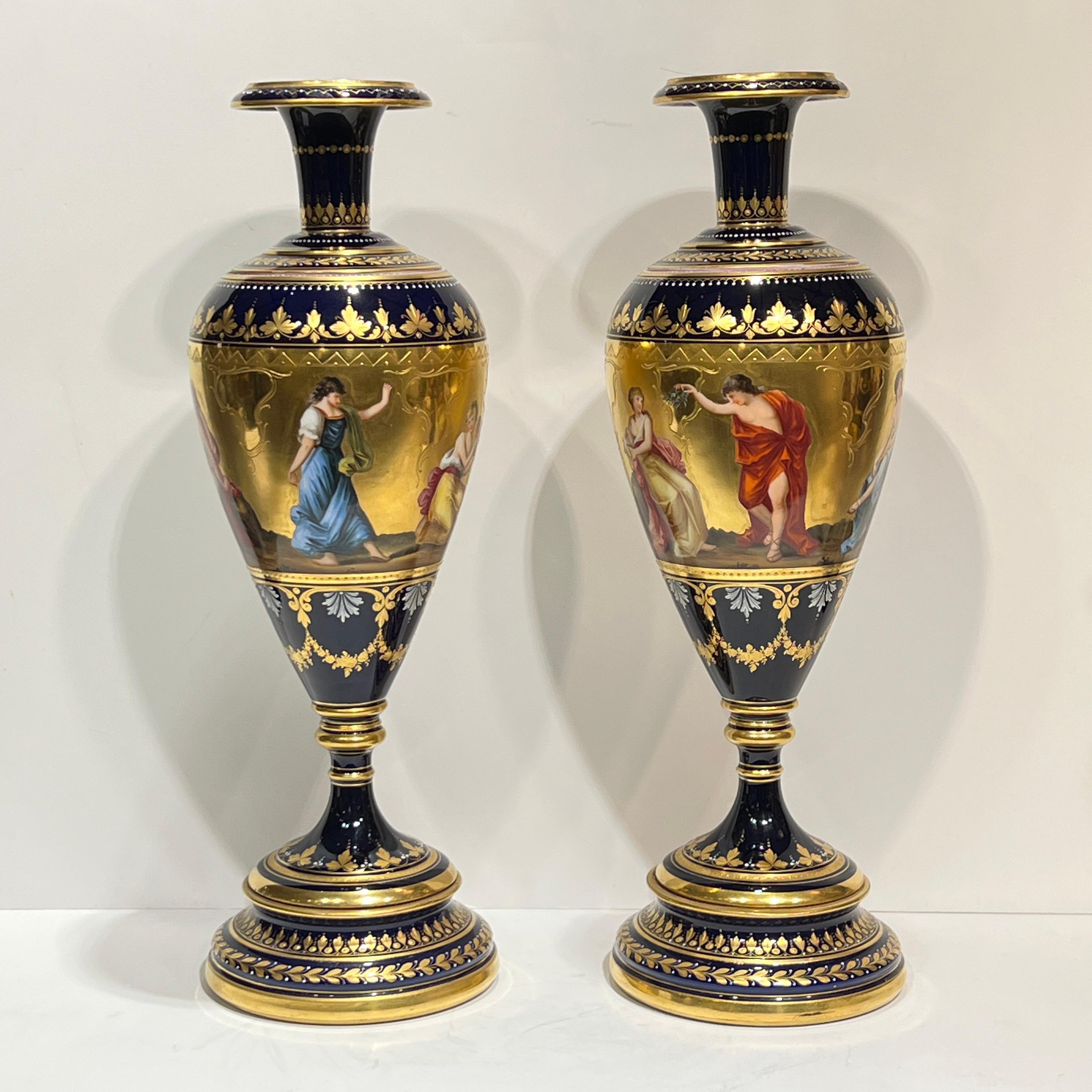 Paire d'exceptionnels vases anciens (XIXe siècle) en porcelaine de Vienne de style néoclassique, avec de fines décorations dorées sur glaçure bleu cobalt et des figures peintes de femmes romaines classiques.  Chacune mesure 17 1/4 pouces de haut et
