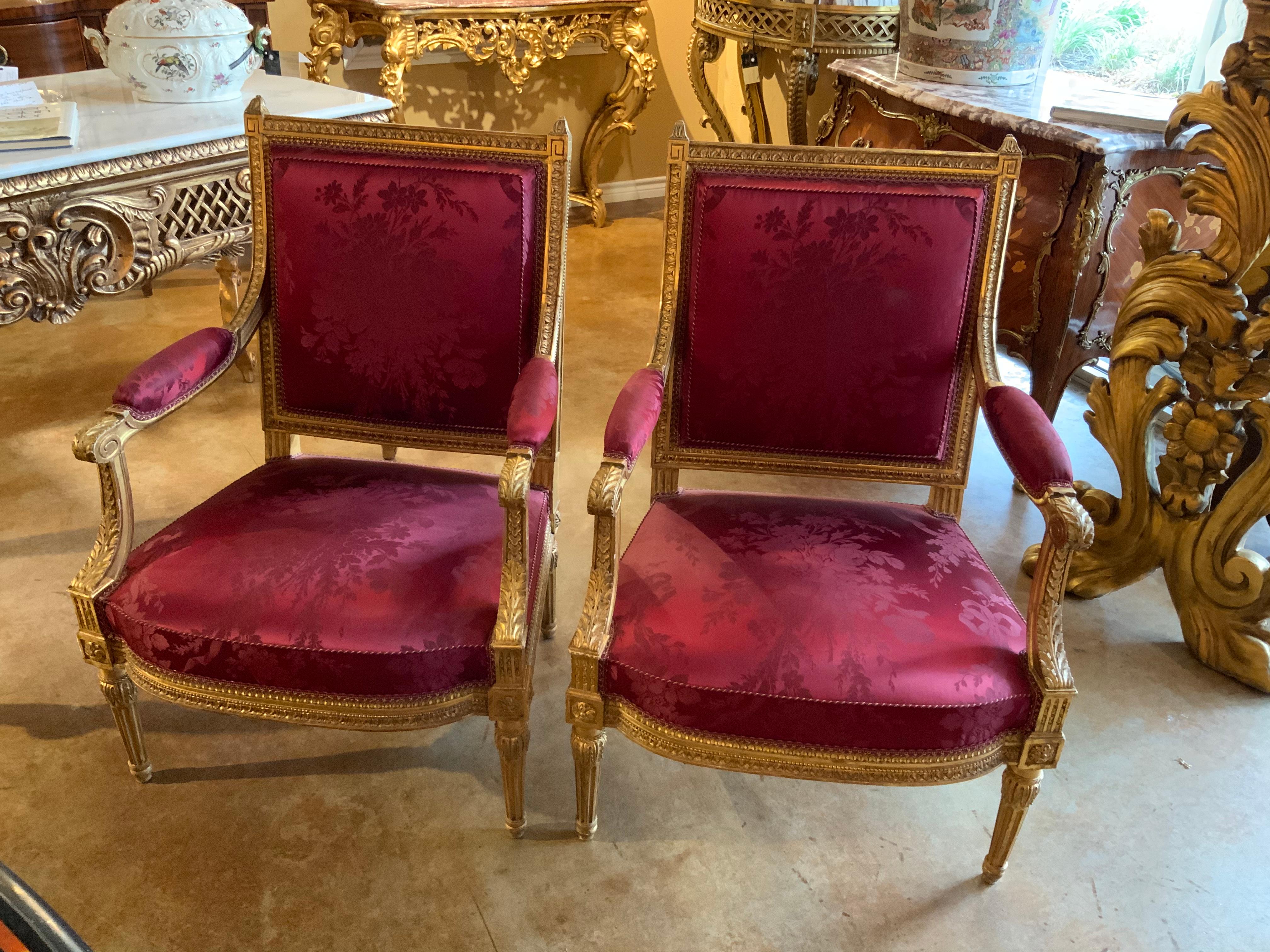 Pair of silk upholstered armchairs with exceptional carving and gilding, 19th century. Louis XVI-style having
a square back and boxed upholstery to the front and a checkered silk upholstery to the back.
The fabric is in great condition and the