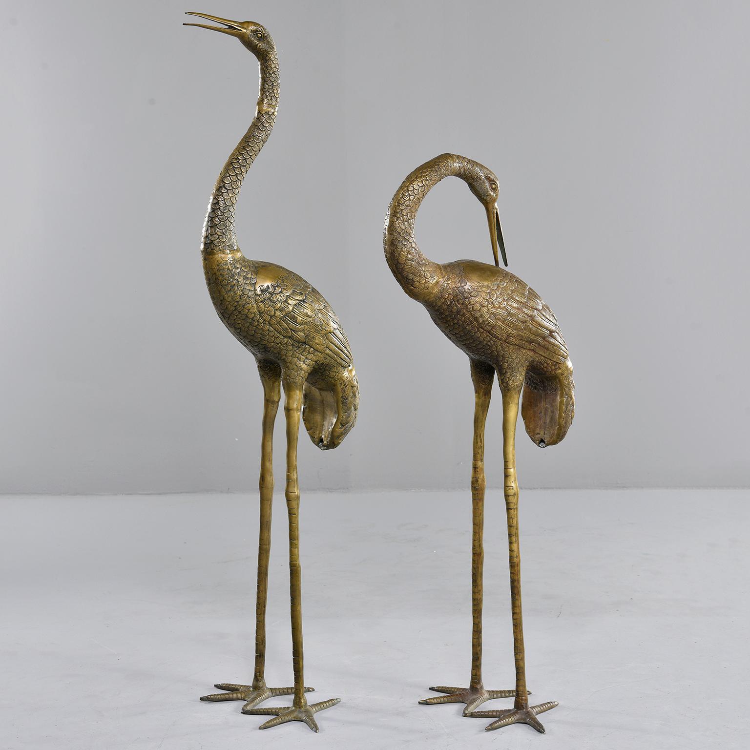 Extra large pair of cast brass crane sculptures, circa 1960s. Unknown maker. Sold and priced as a pair. Measurements shown are for the taller crane. Smaller crane measures: 47” high x 17” wide x 16.5” deep.